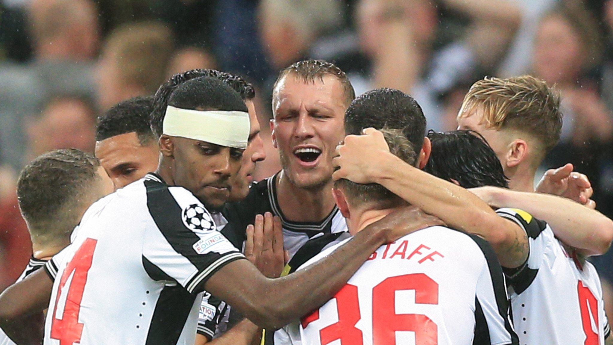 Newcastle players celebrate after Dan Burn scores their second gaol against PSG