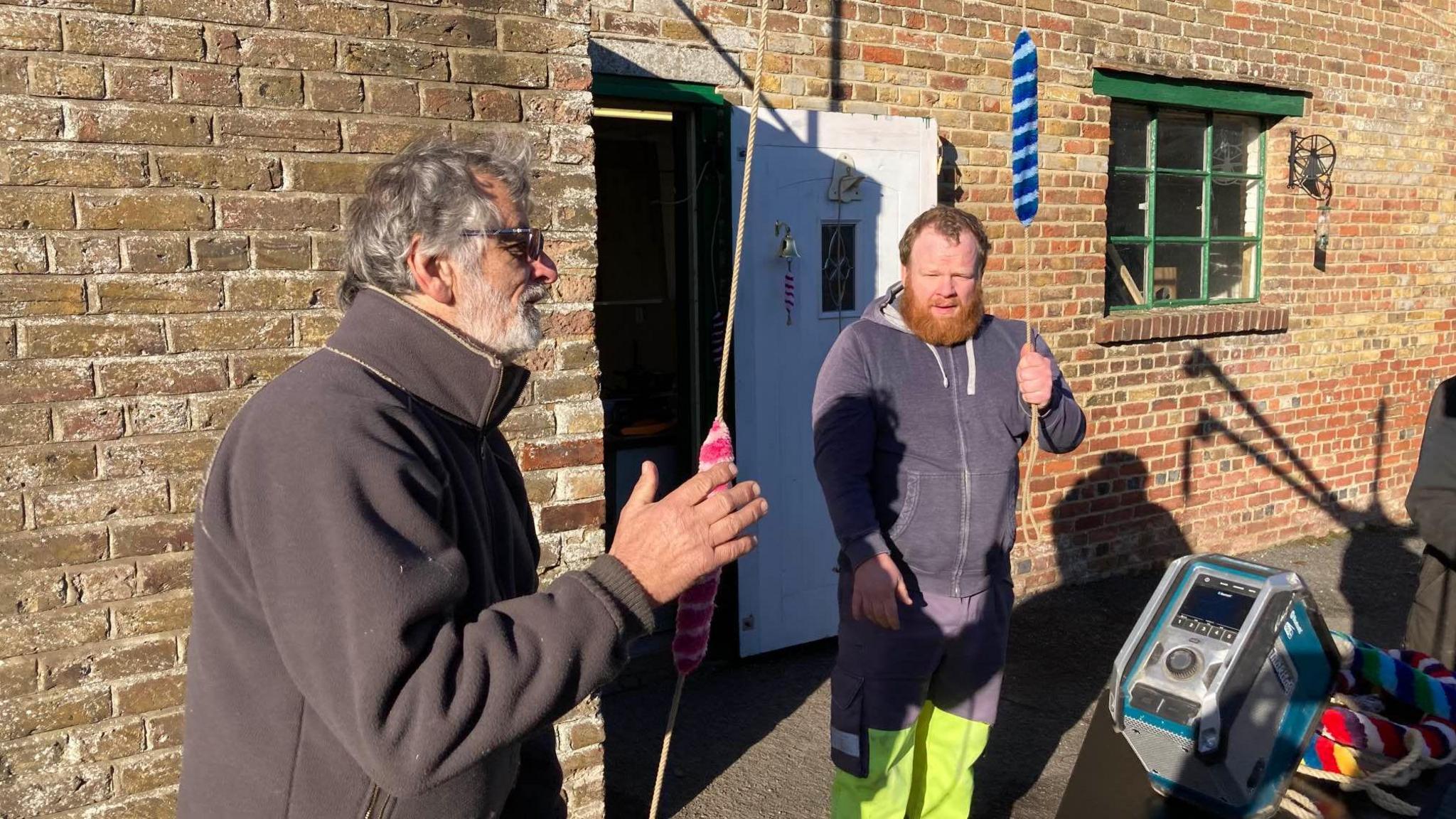 Bell ringers Trevor Arnold and Phil Fagg holding ropes