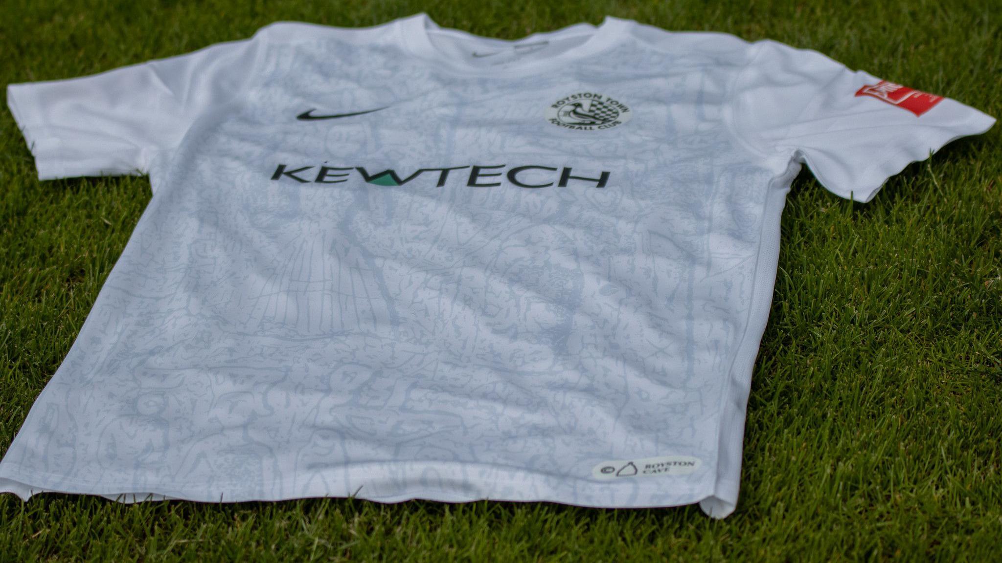 A football kit with cave designs on, placed on a football pitch