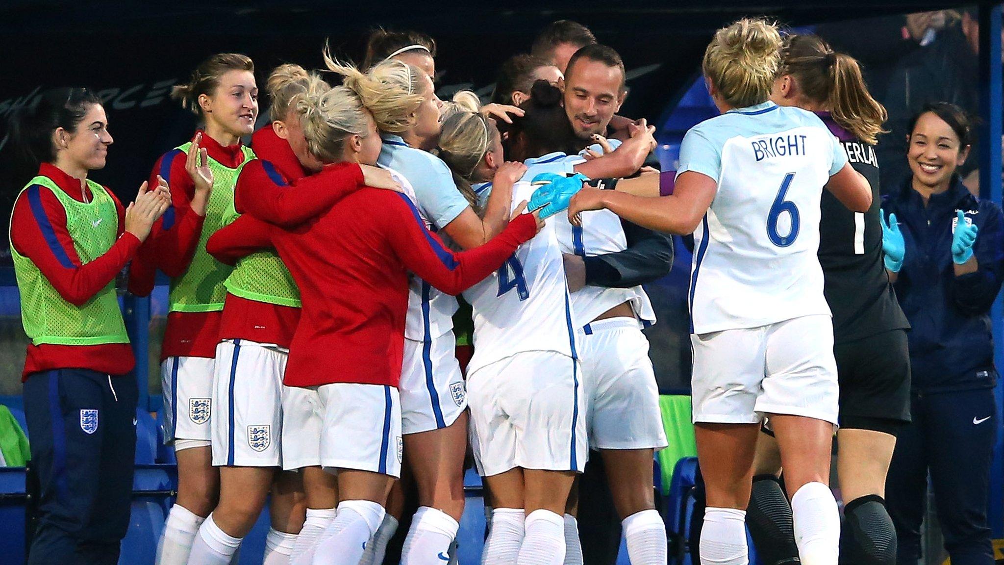 England players celebrate with Mark Sampson after scoring against Russia