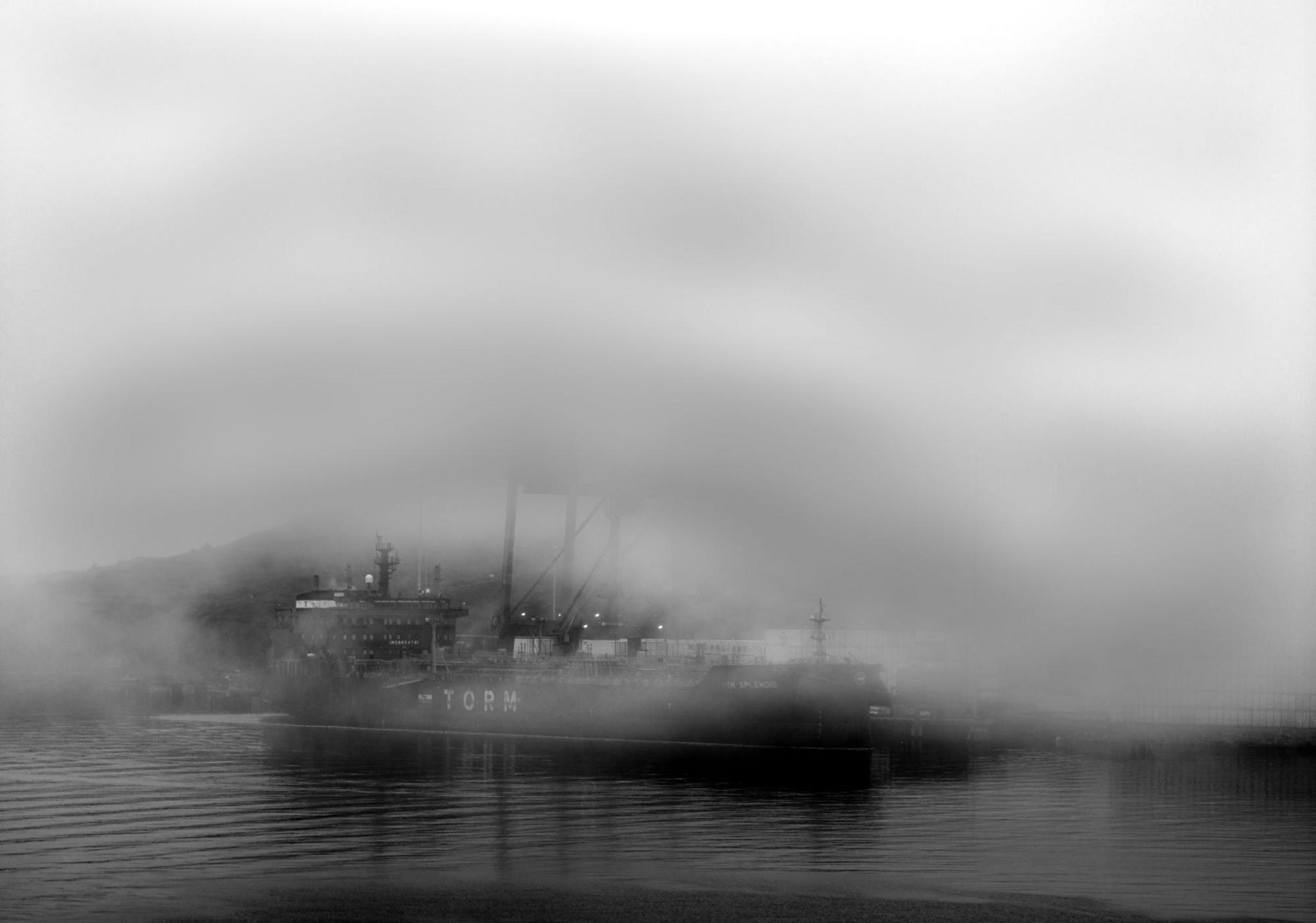 A ship in harbour surrounded by fog