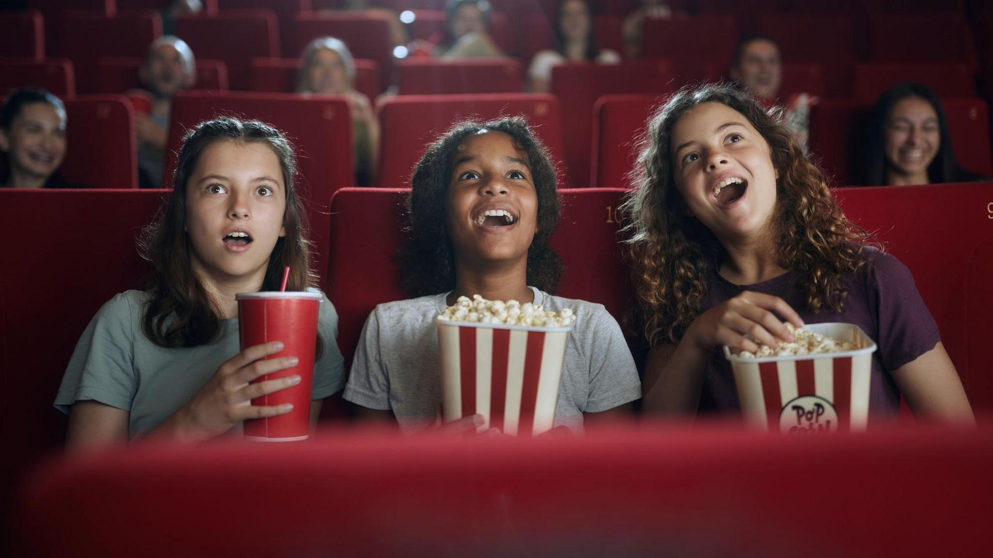 children in cinema eating popcorn.