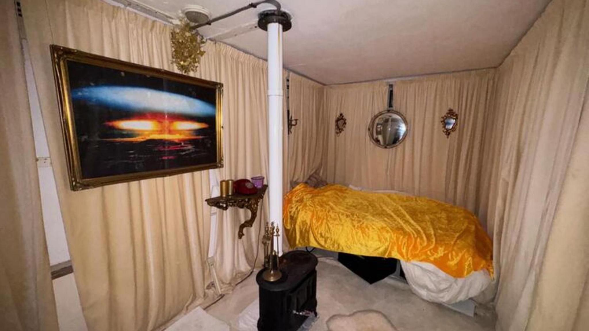 Velvet curtains and a yellow bed inside the bunker