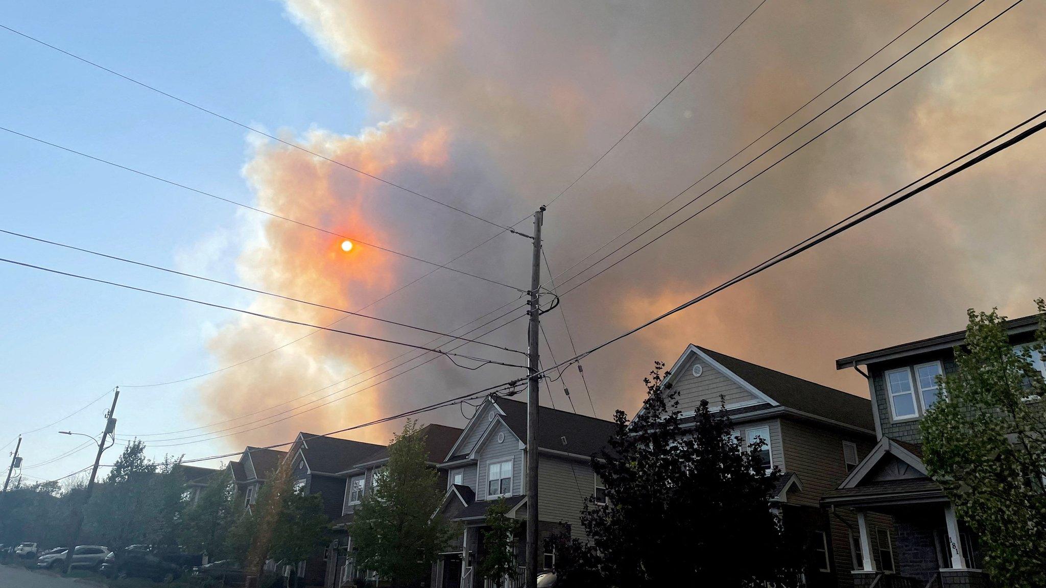 Smoke from the Tantallon wildfire rises over houses in nearby Bedford, Nova Scotia, Canada, May 28, 2023