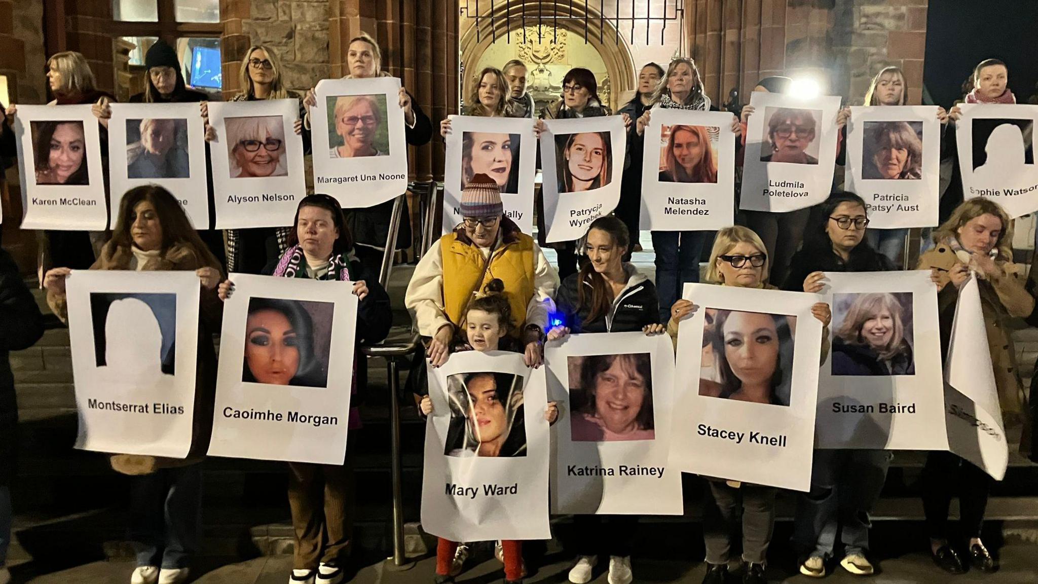 Women holding pictures of women killed in Northern Ireland