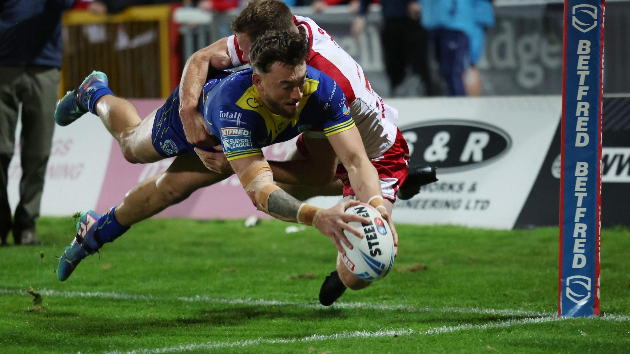 Warrington's Matty Ashton dives over to score against Hull KR