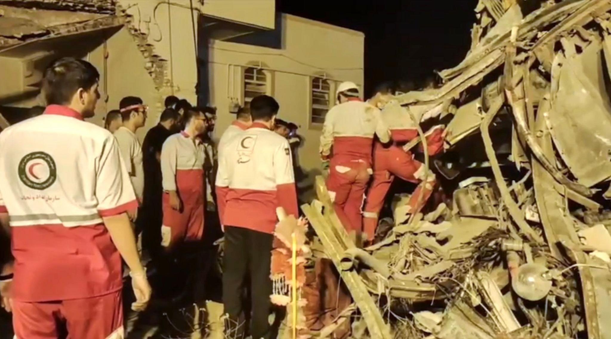 A screen grab shows members of the Iranian Red Crescent Society inspecting a pile of wreckage at the bus crash site. 