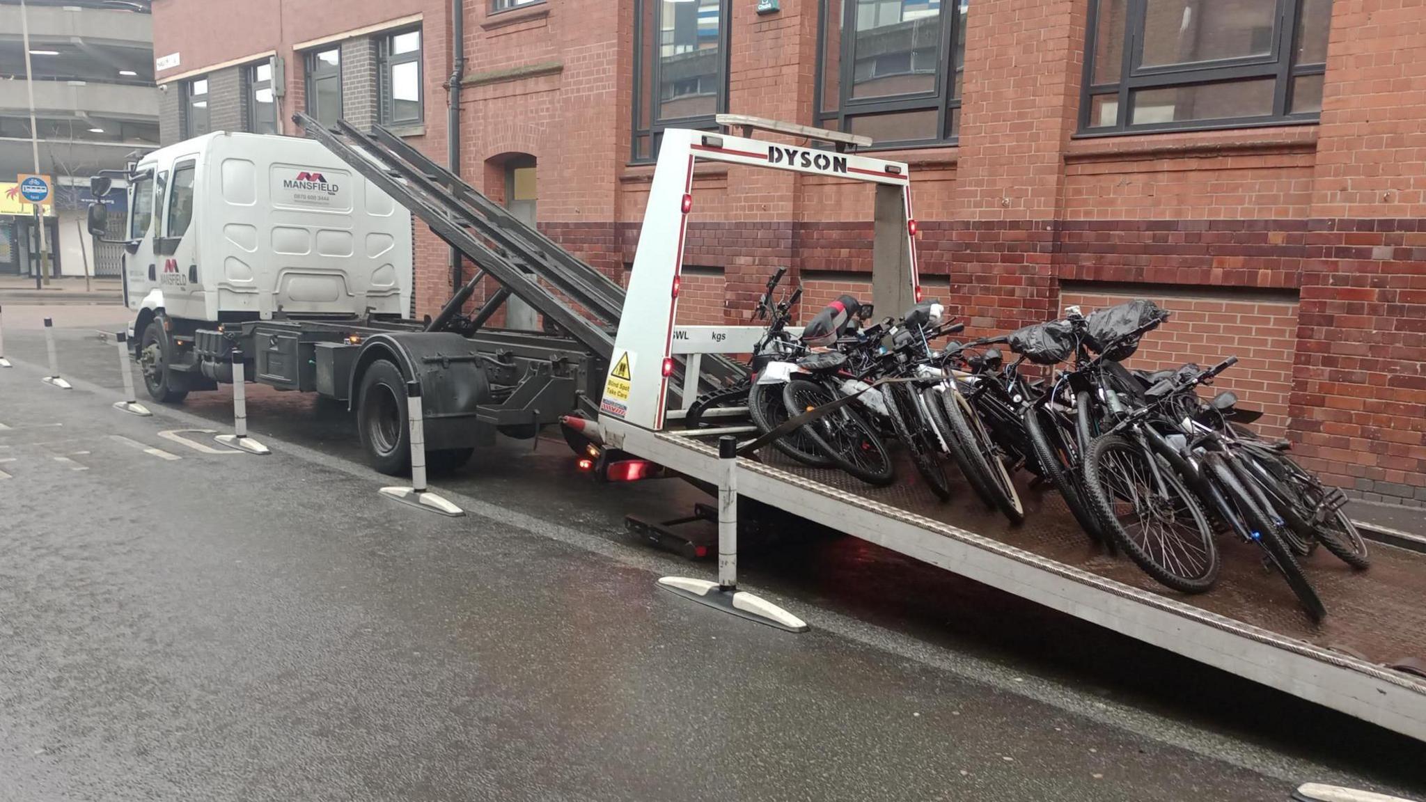 A recovery lorry with more than a dozen seized bikes on the back of it