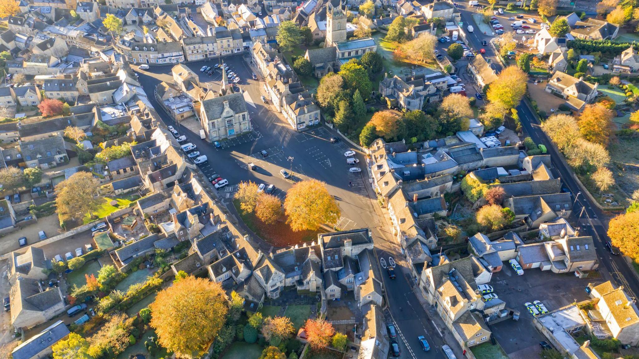 Aerial photo of Stow-on-the-Wold town centre. It shows the Market Square and numerous Cotswold stone buildings from above.