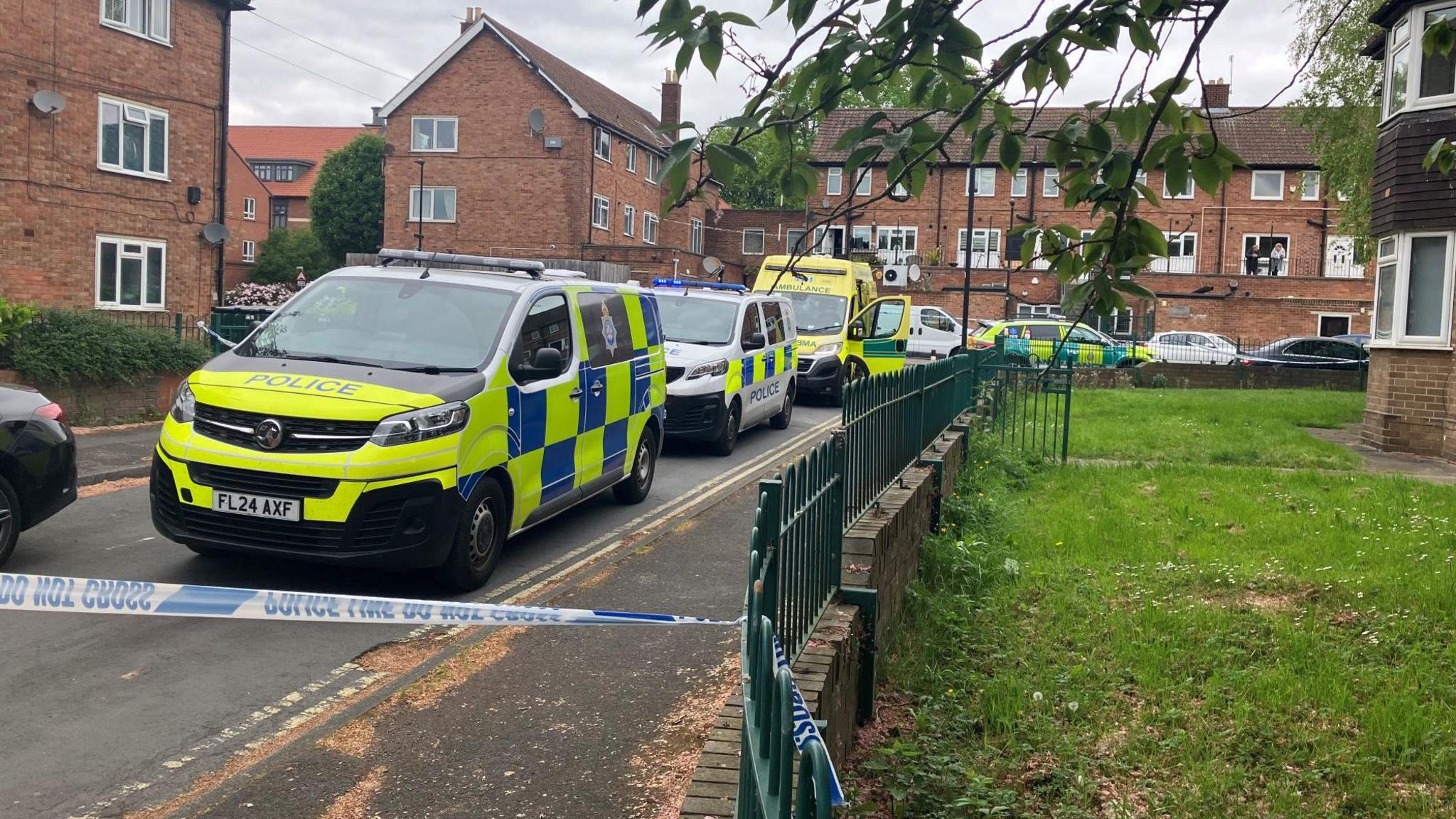 Police vans and ambulances in a cordoned off residential street