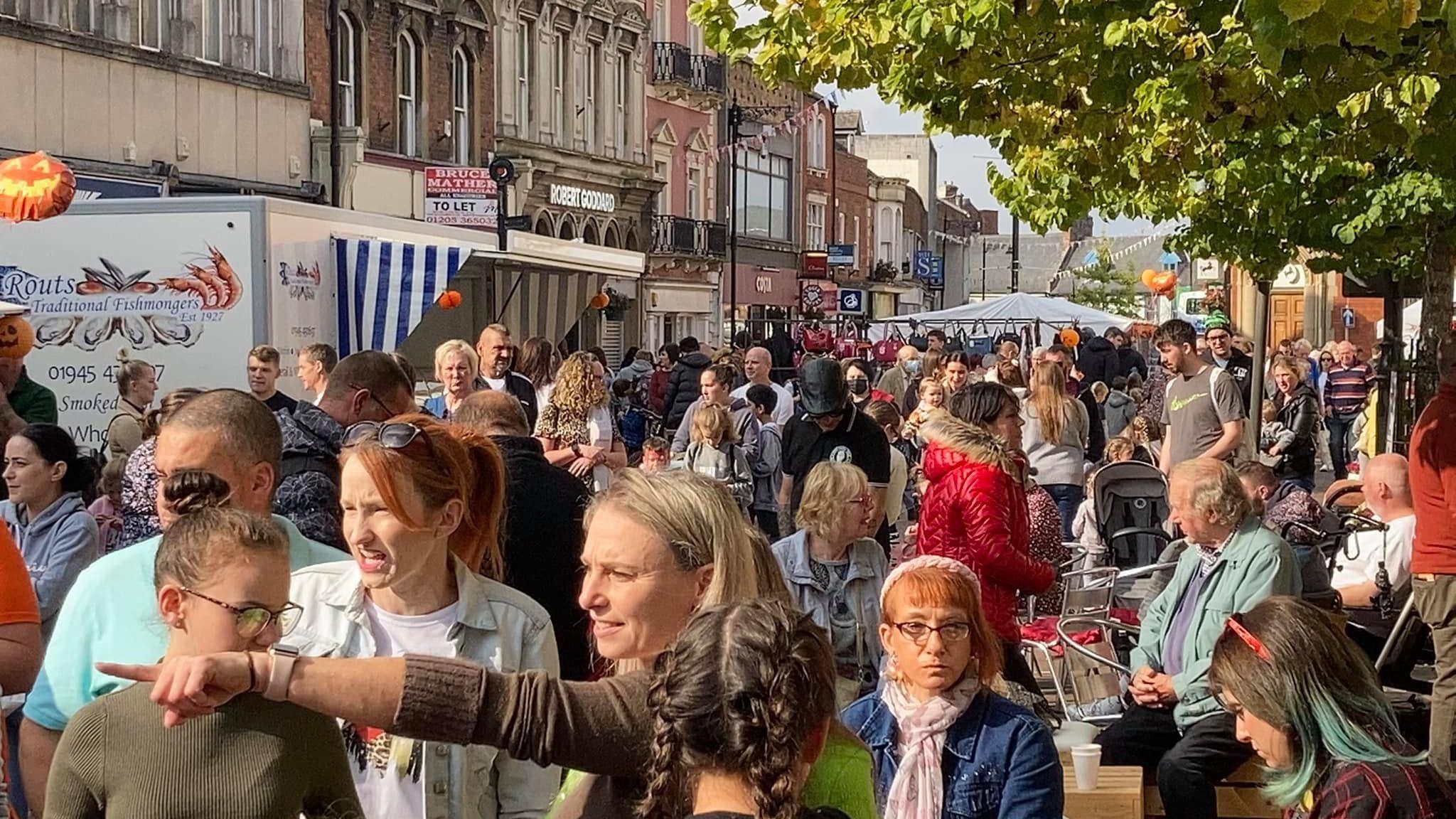 Crowds of people can be seen in Spalding town centre, with some sitting down to enjoy food and drink and others taking in the sights. 