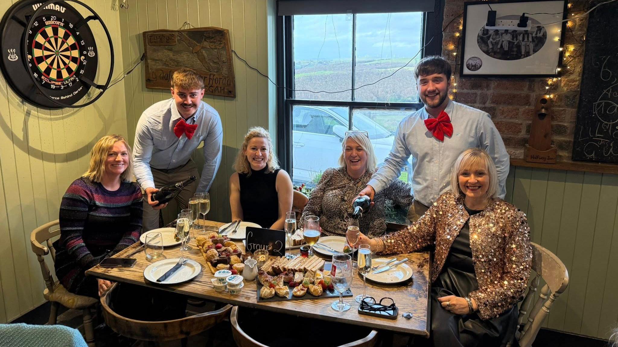 Grwp o bobl yn y dafarn