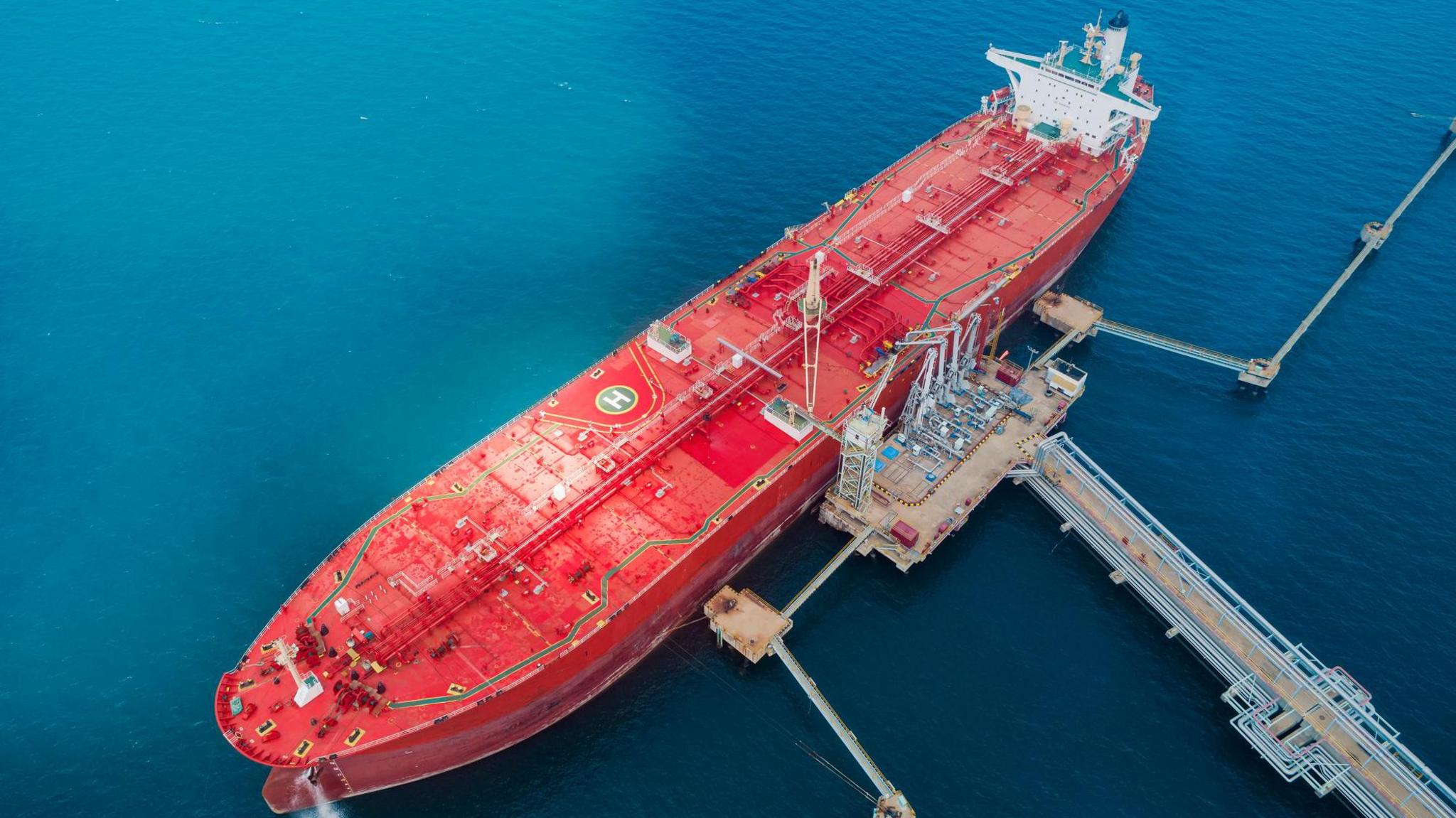 Aerial view of oil ship tanker at a loading dock for transportation of oil from refinery on the sea.