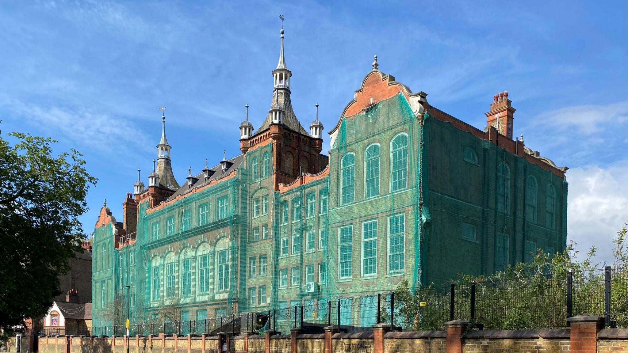 Green safety netting covers Kennington Boys' School in London