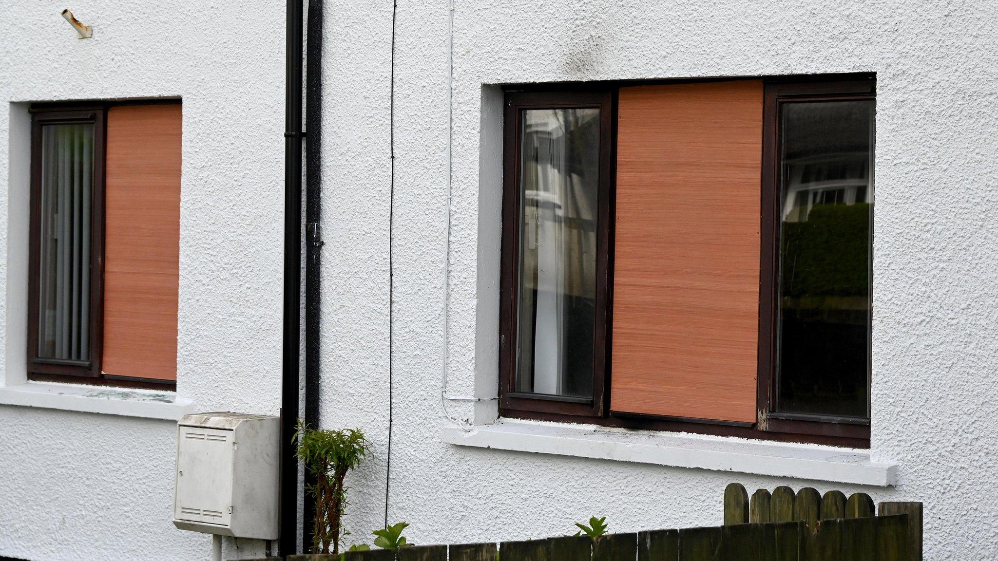 Two windows boarded up with wood