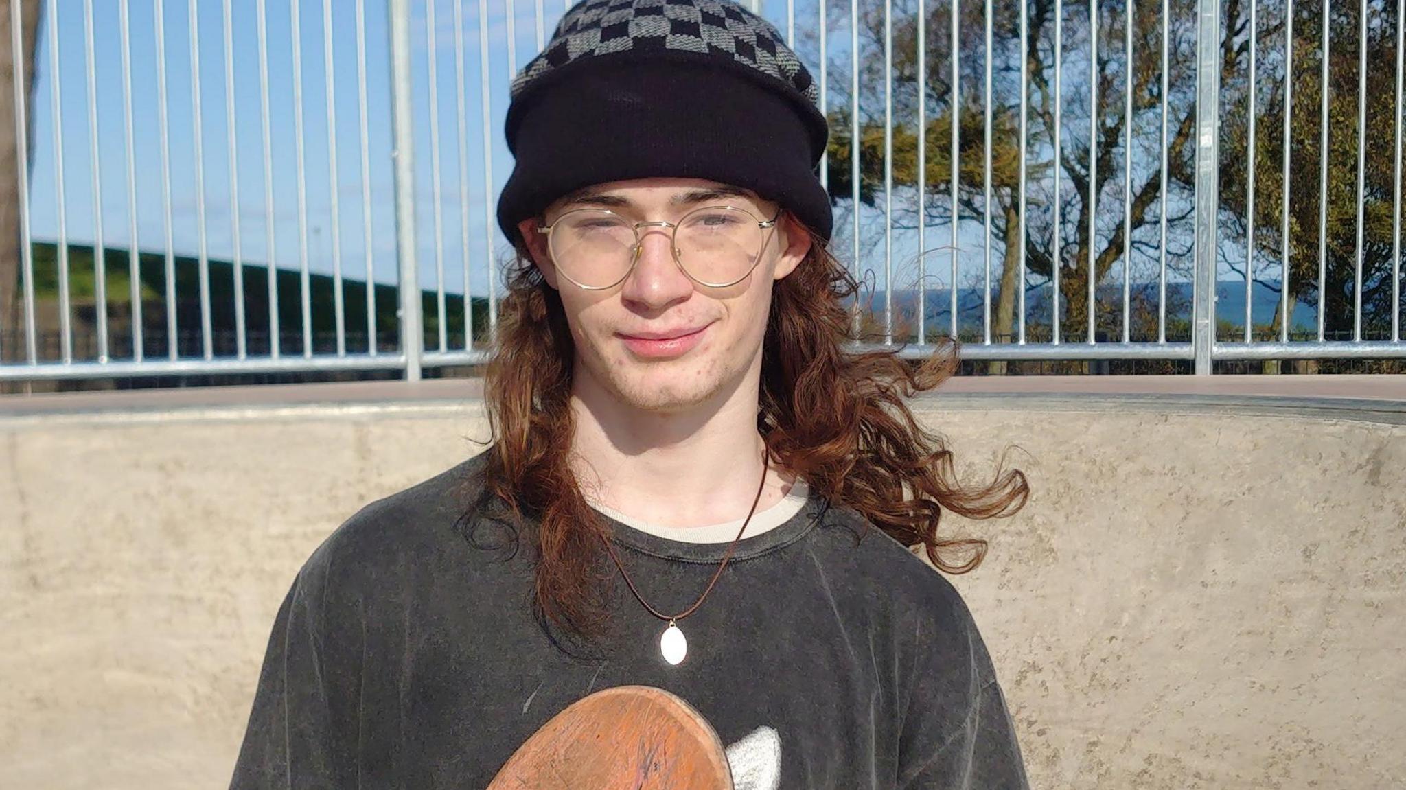 A young man holds his skateboard at the new skate park in Larne.