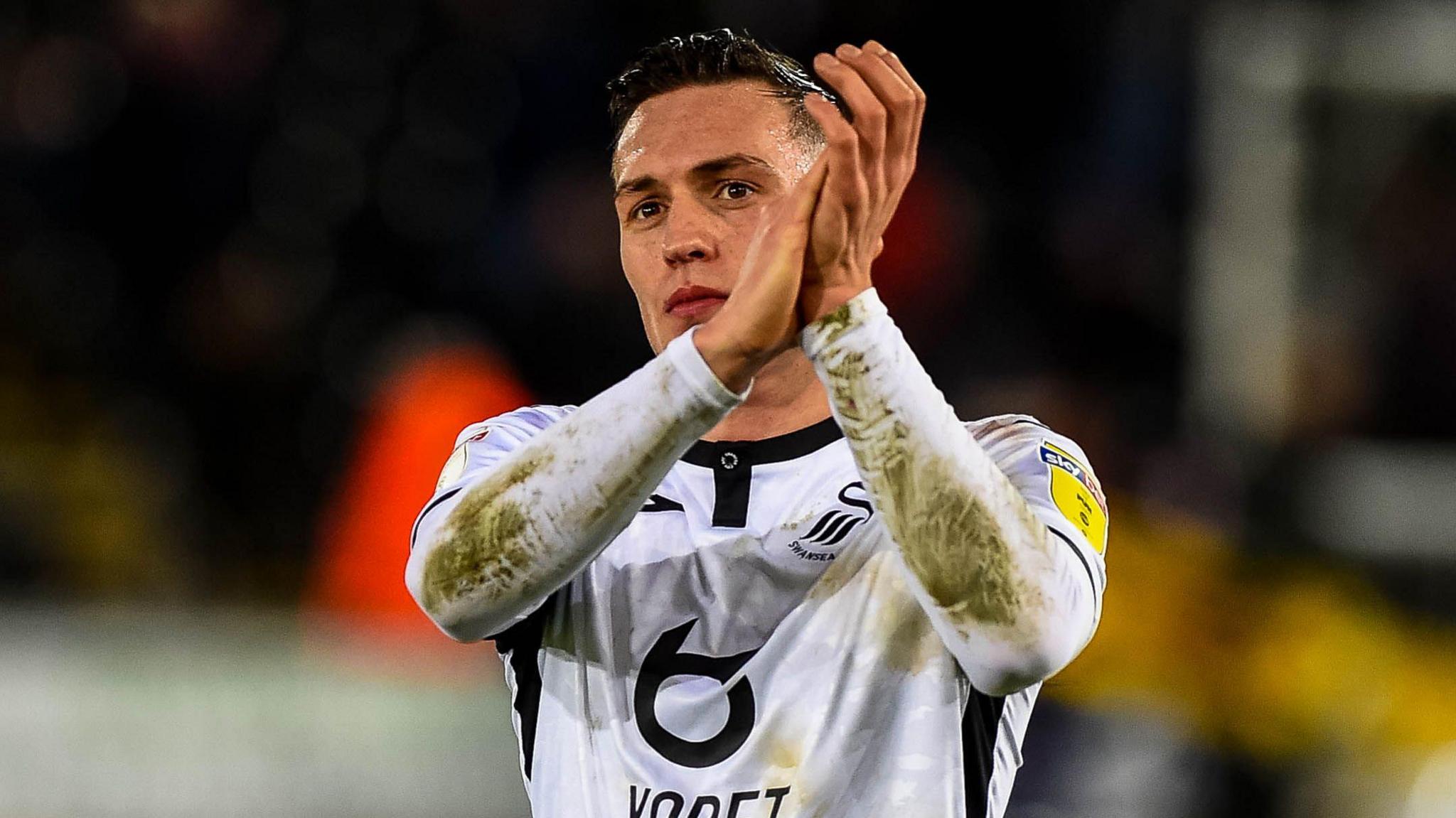 Connor Roberts applauds fans during his time at Swansea 