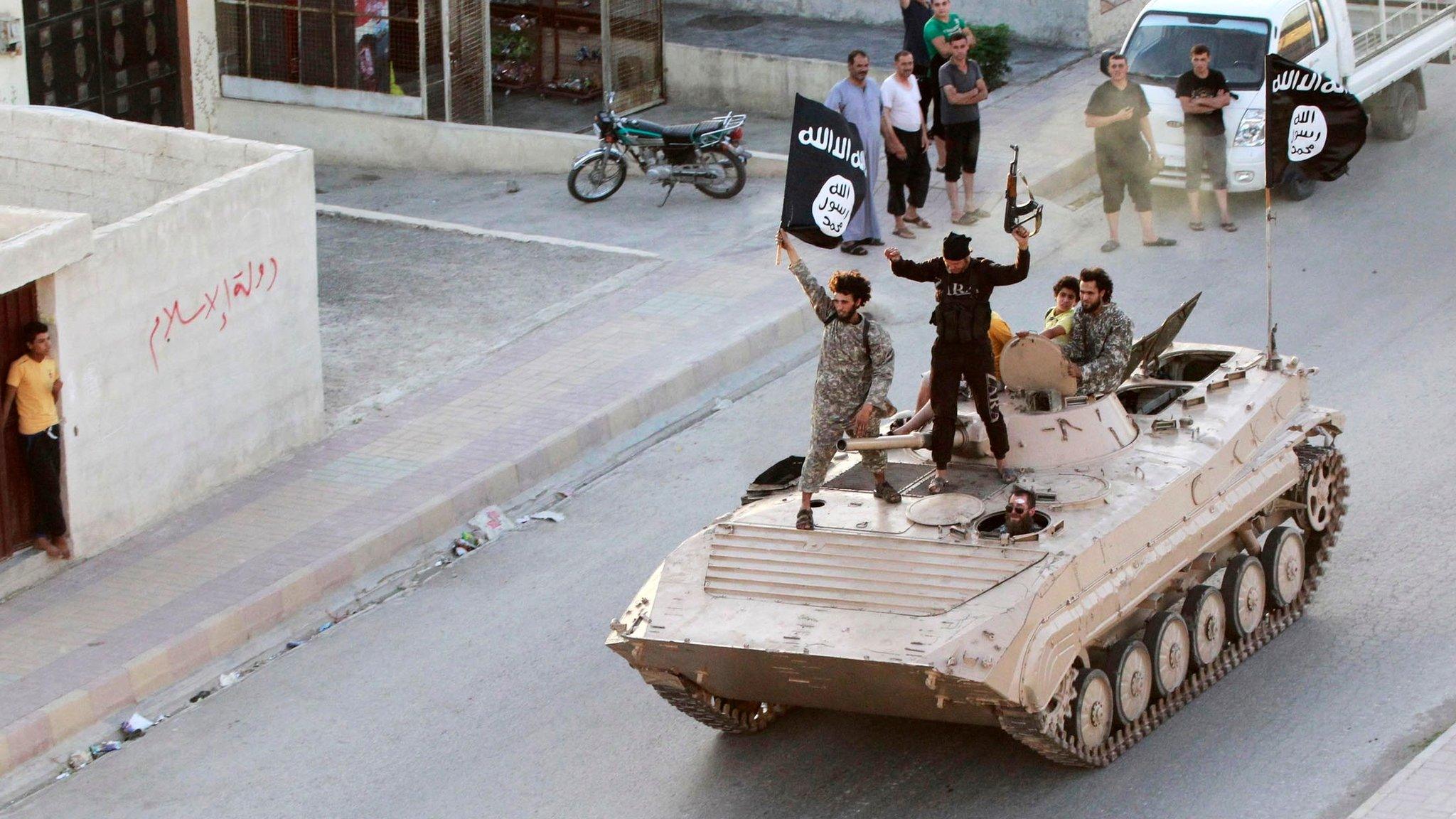 Islamic State militants take part in a military parade along the streets of Raqqa, Syria, on 30 June 2014