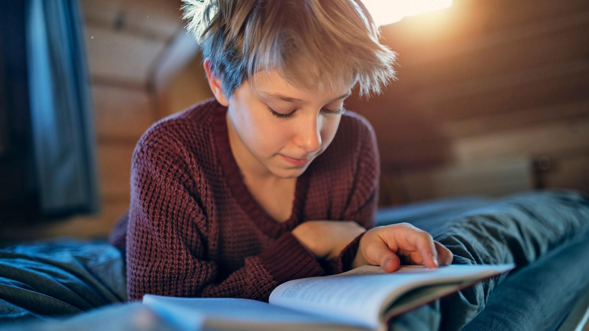 boy reading on his bed. 