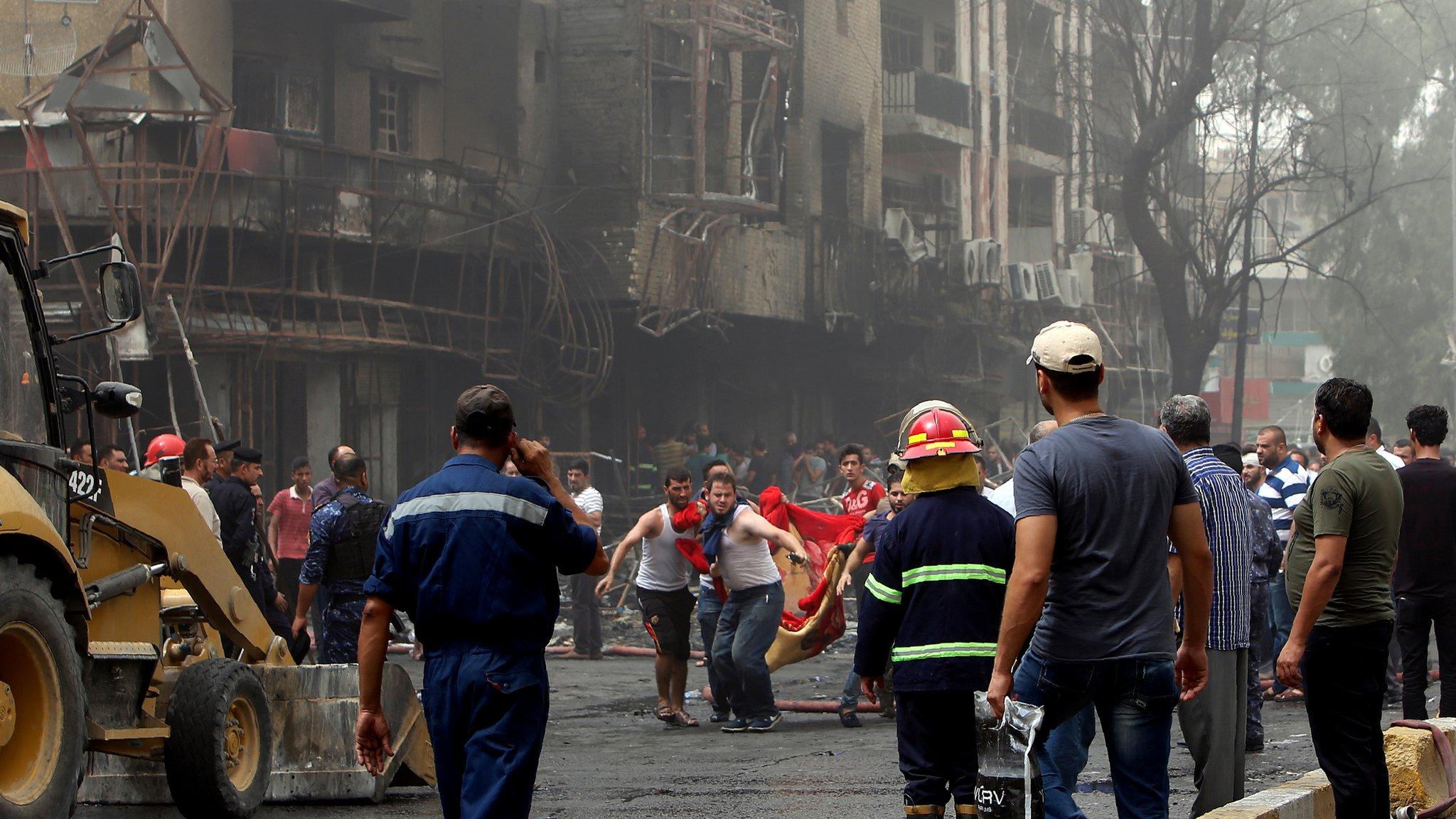 People gather at the site of a suicide car bomb in the Karrada shopping area, in Baghdad, Iraq July 3, 2016