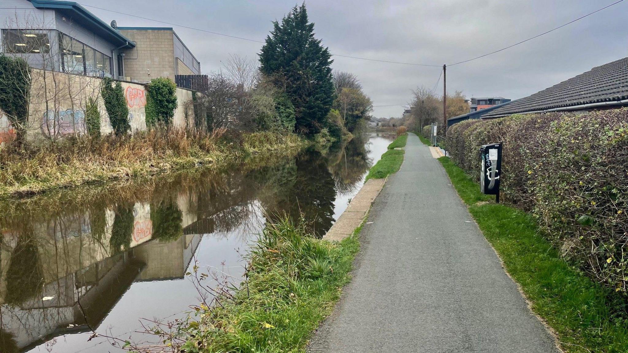 The Union canal with a long empty path next to it.