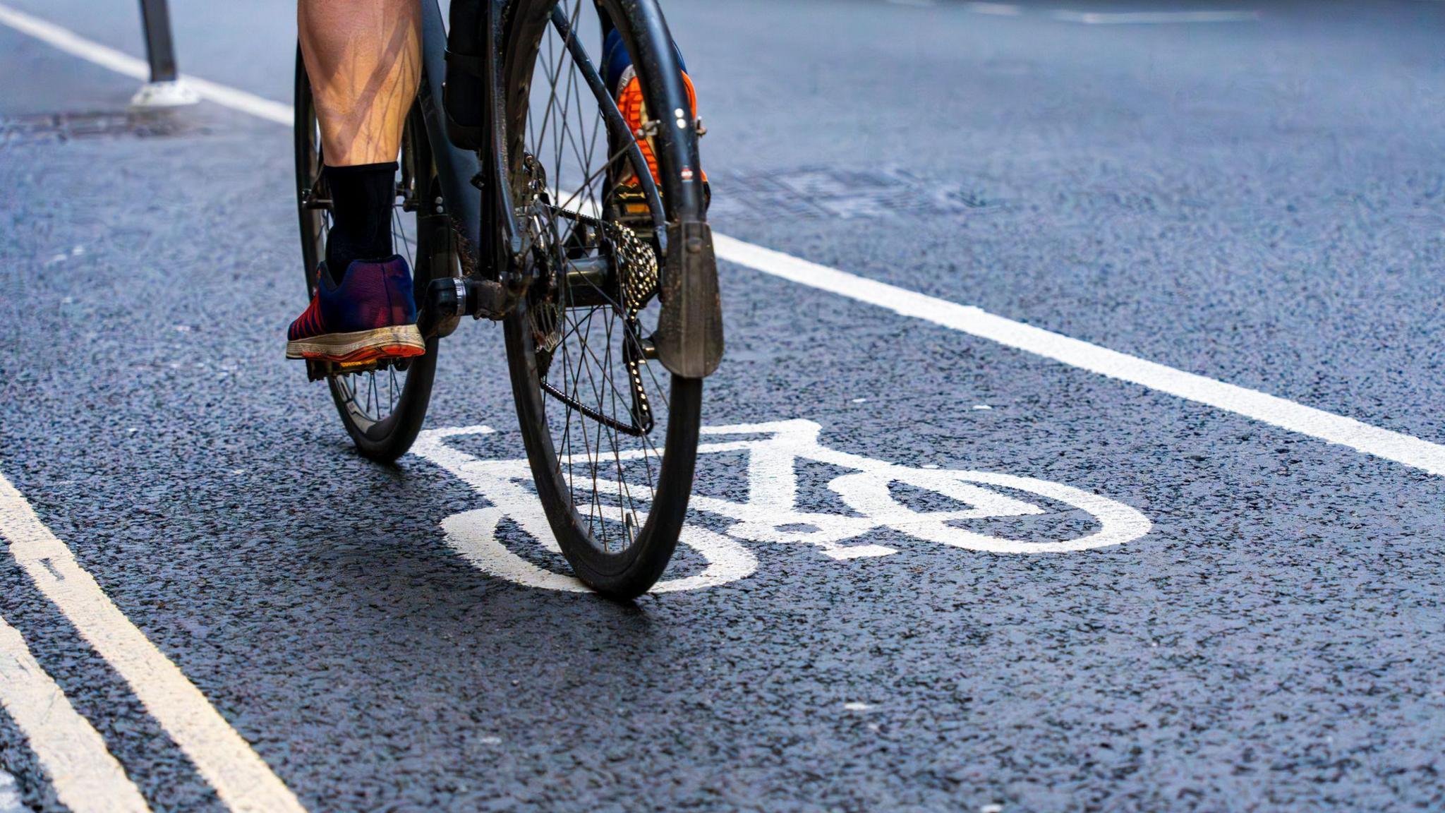 A stock image of a man on a bike cycling along a cycle path