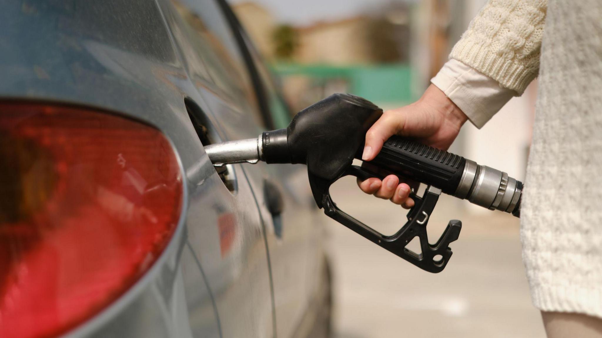 A woman filling up her car with fuel