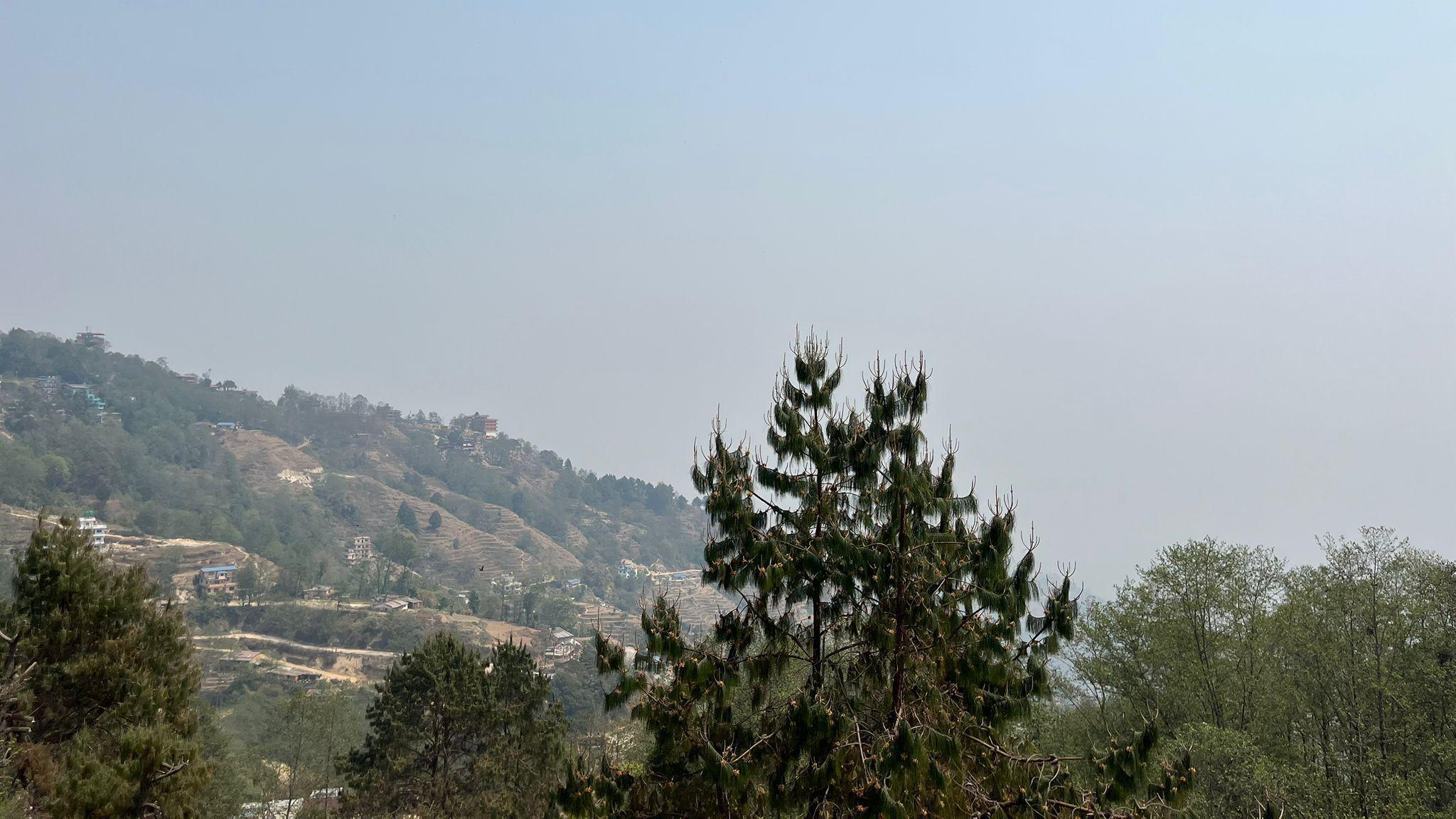 View of a hill in the foreground with nothing visible behind, due to haze