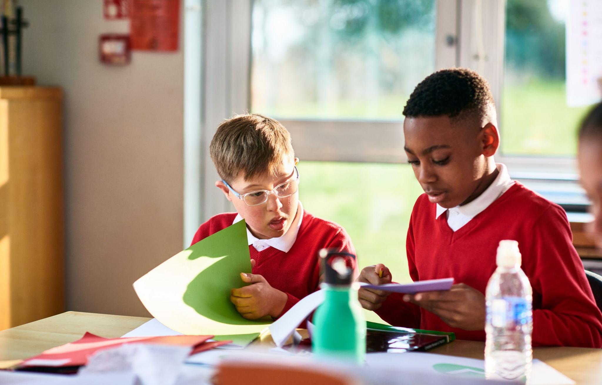 boy with down syndrome and classmate learning.