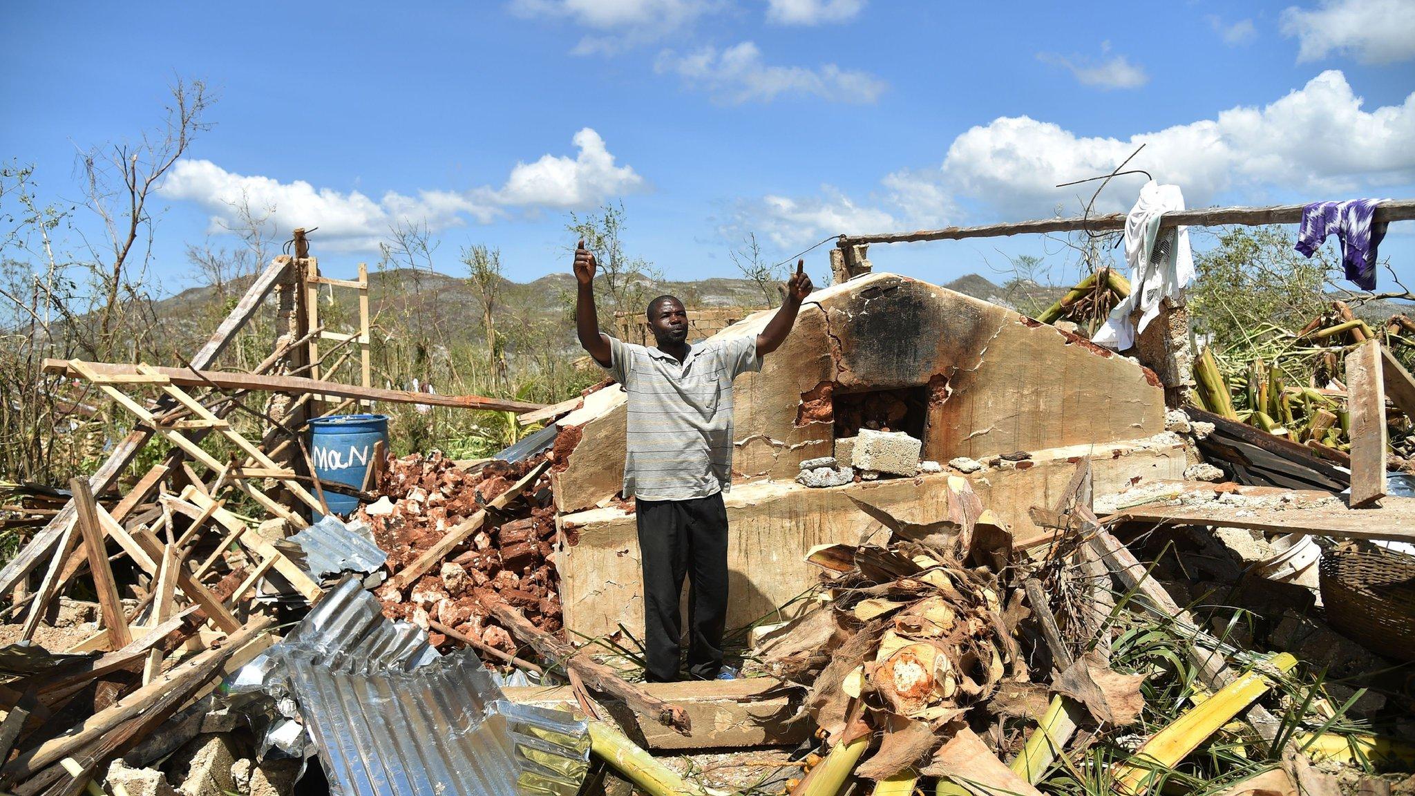 A man gestures while standing in his house in Deson, near Les Cayes in south-west Haiti.