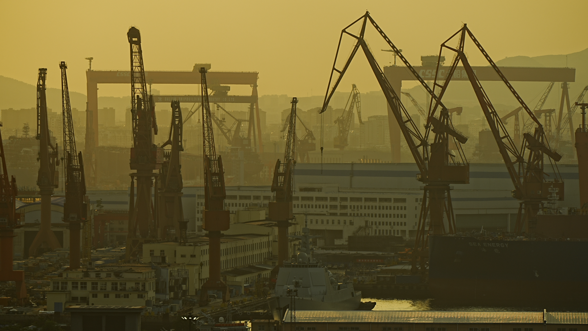 A dockyard in China is photographed in a hazy, yellow light.