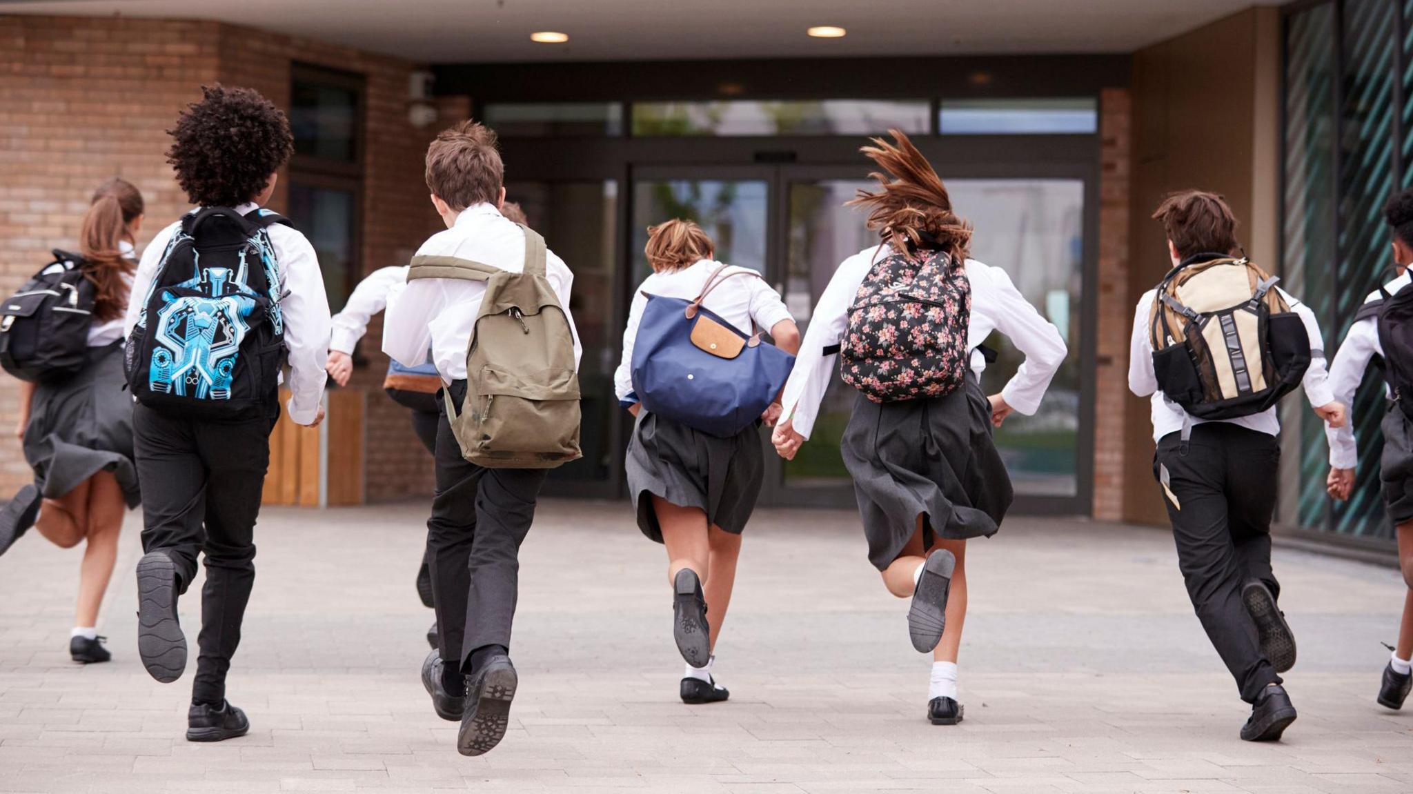 children running into the entrance of school