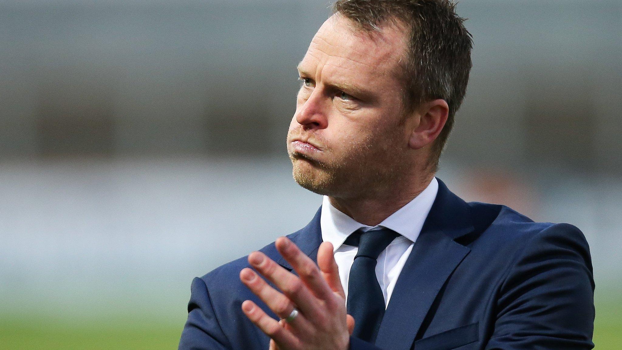 Michael Flynn puffs out his cheeks as he applauds fans following Newport County's win over Cambridge United in the FA Cup