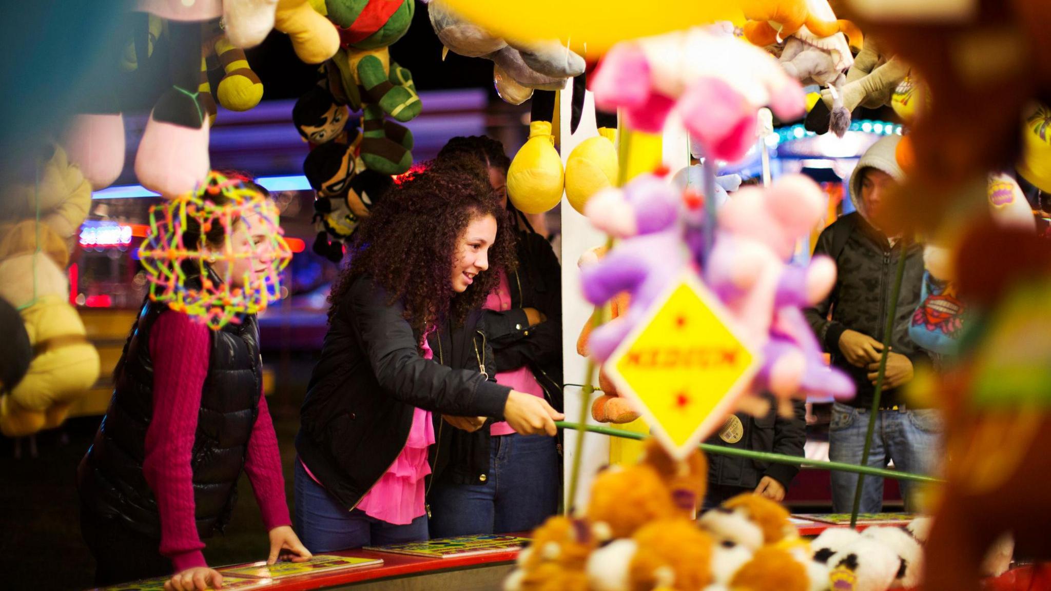 girl playing hook a duck with friends.