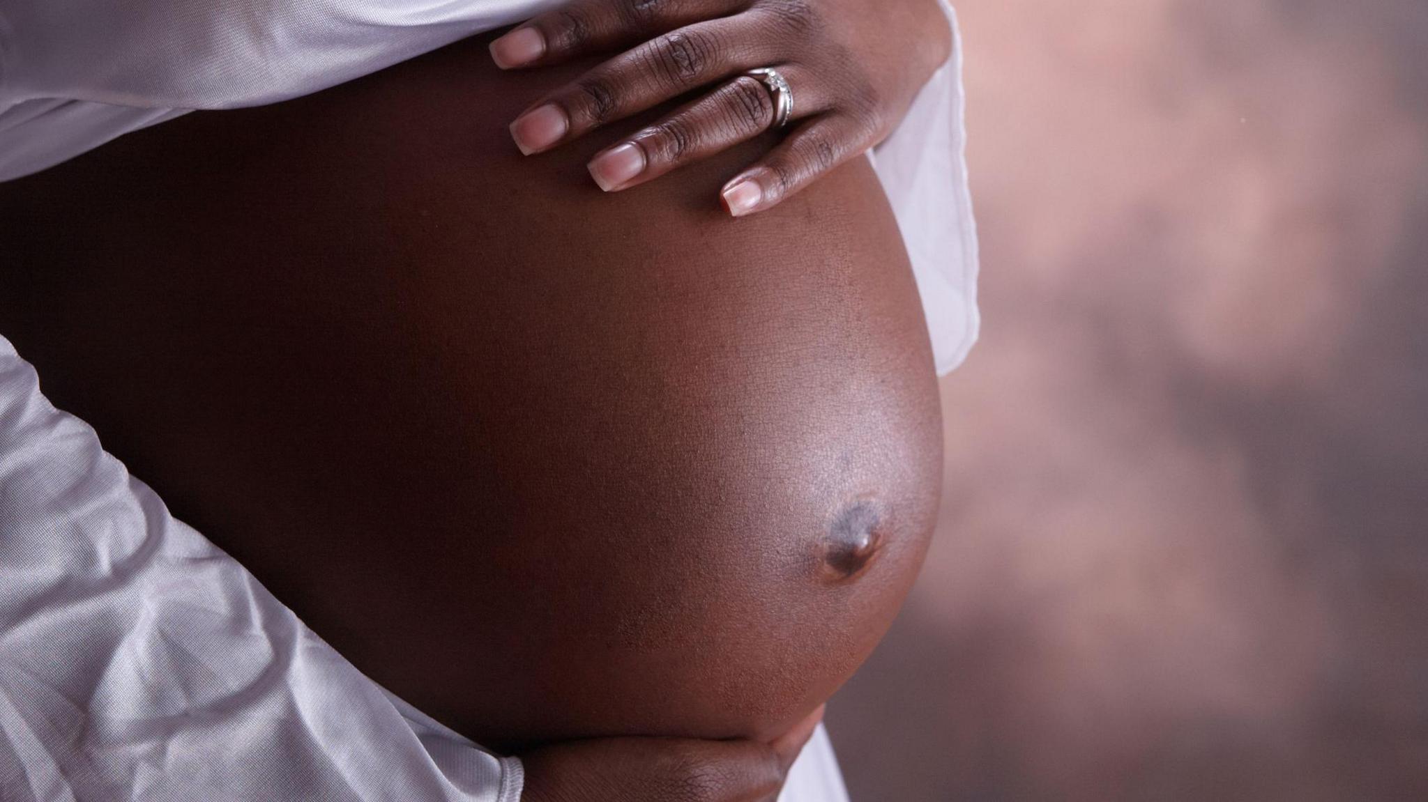 A close-up photo of a woman's pregnant stomach.