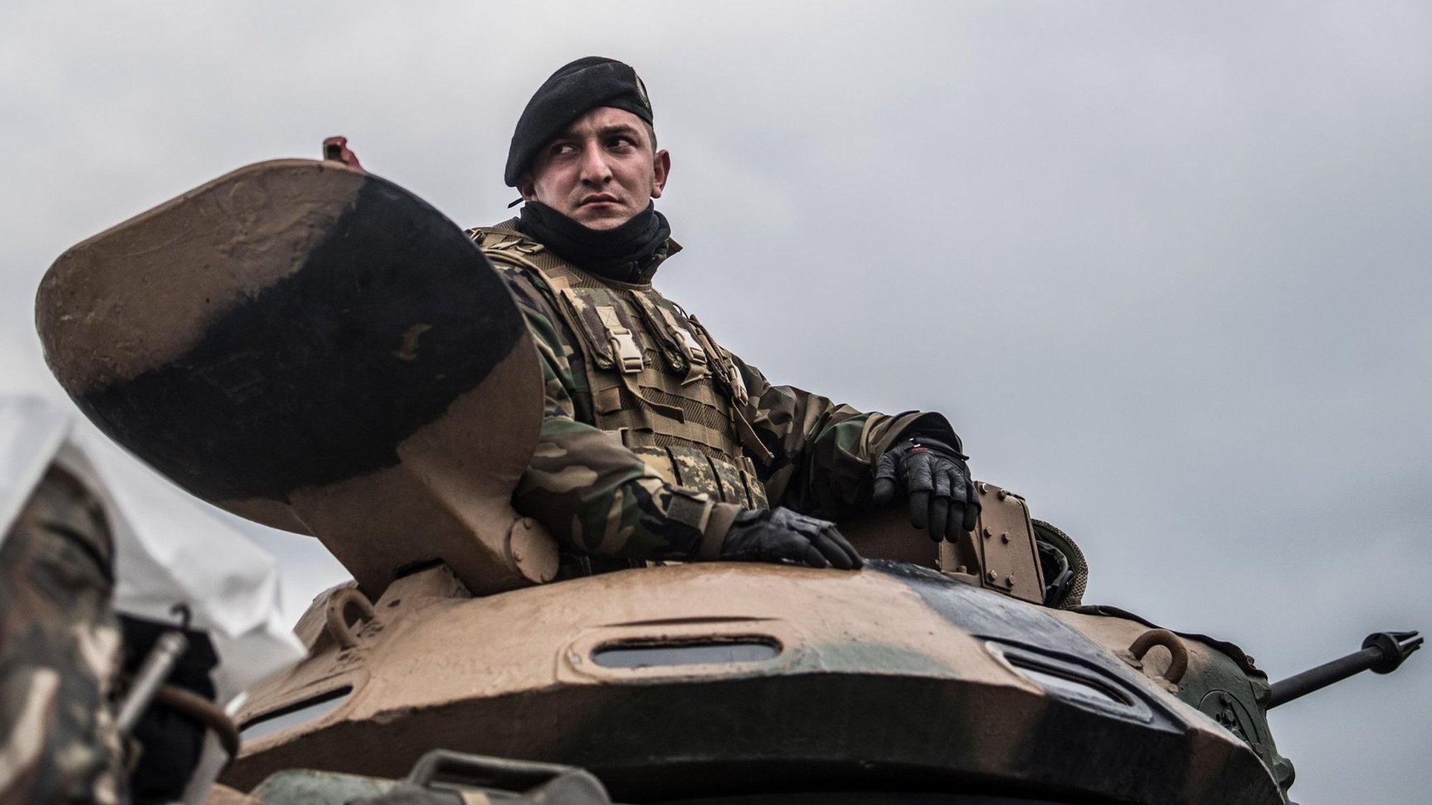 A Turkish army soldier sits in a tank waiting near the Syrian border before entering neighbouring Syria on 21 January 2018 at Hassa, in Hatay province, Turkey