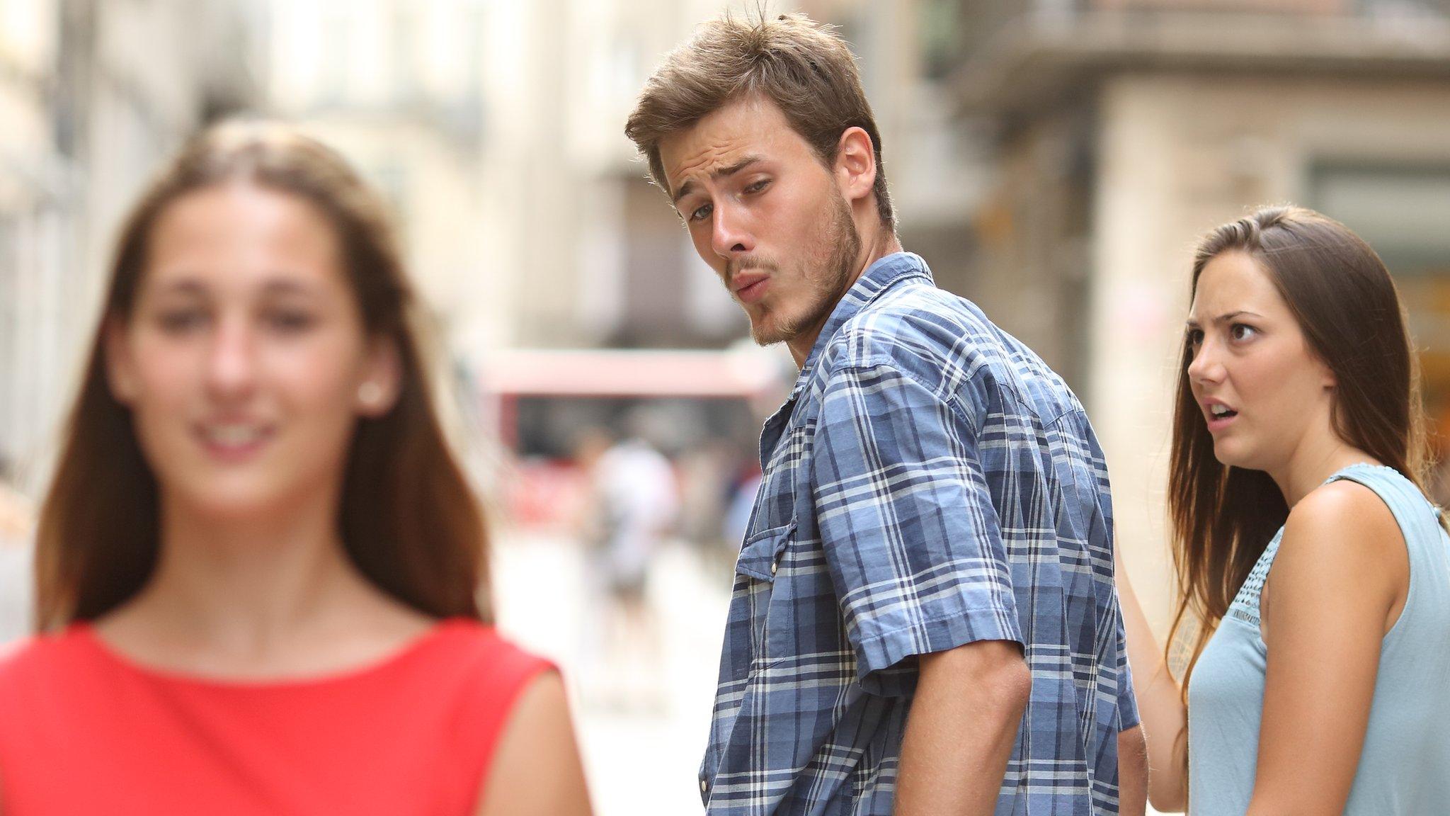 A distracted boyfriend looks at another woman while his girlfriend looks on in disgust