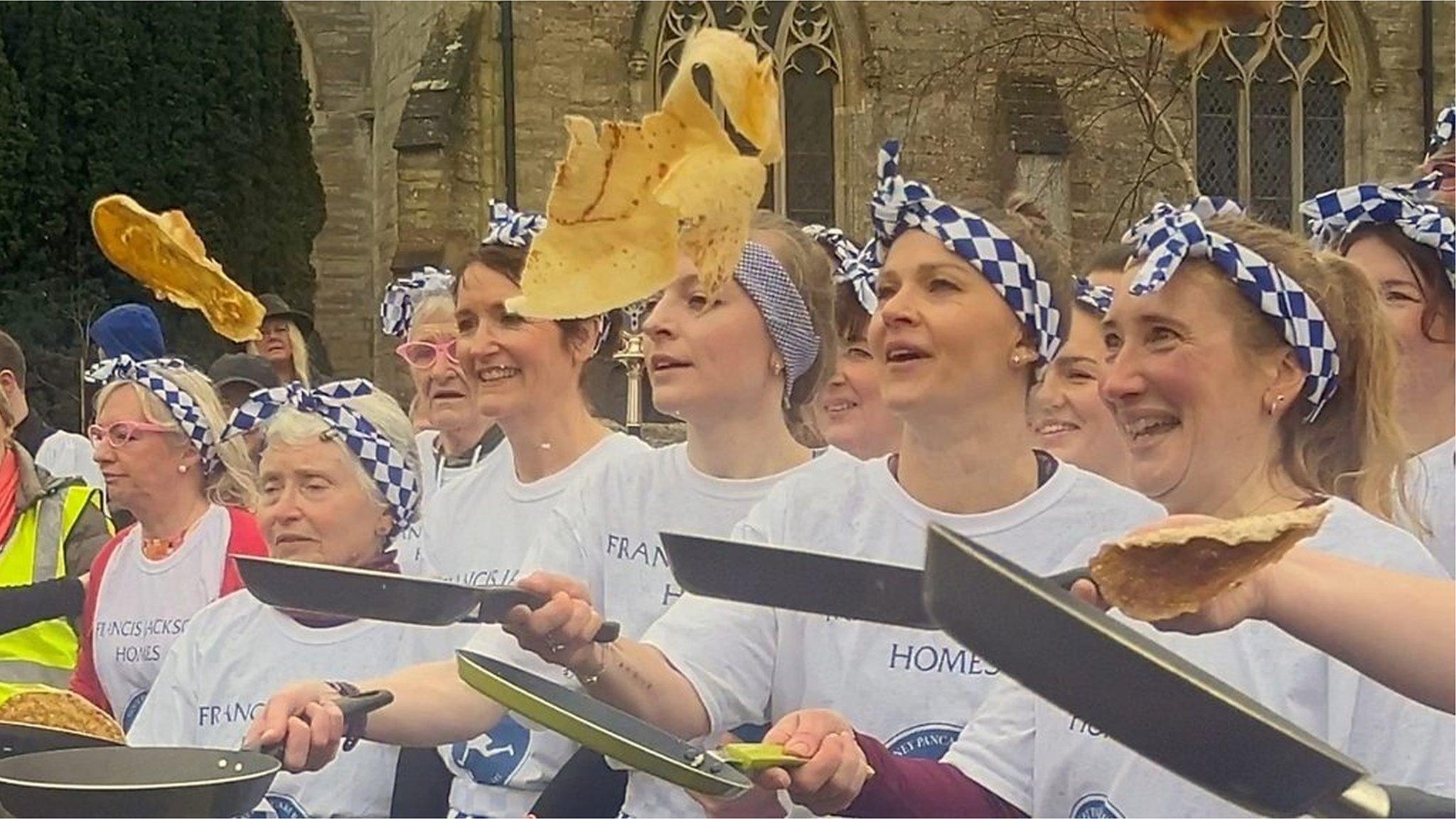 People tossing pancakes in Olney.