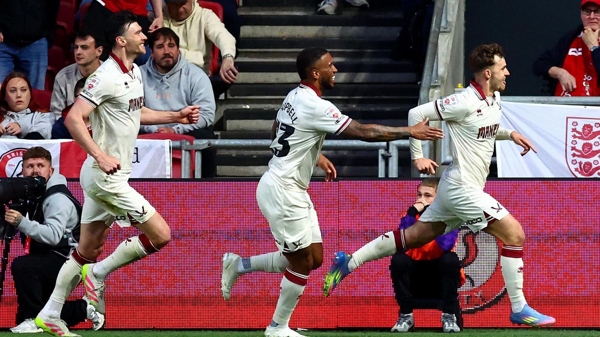 Harrison Burrows (far right) runs in celebration after scoring a penalty