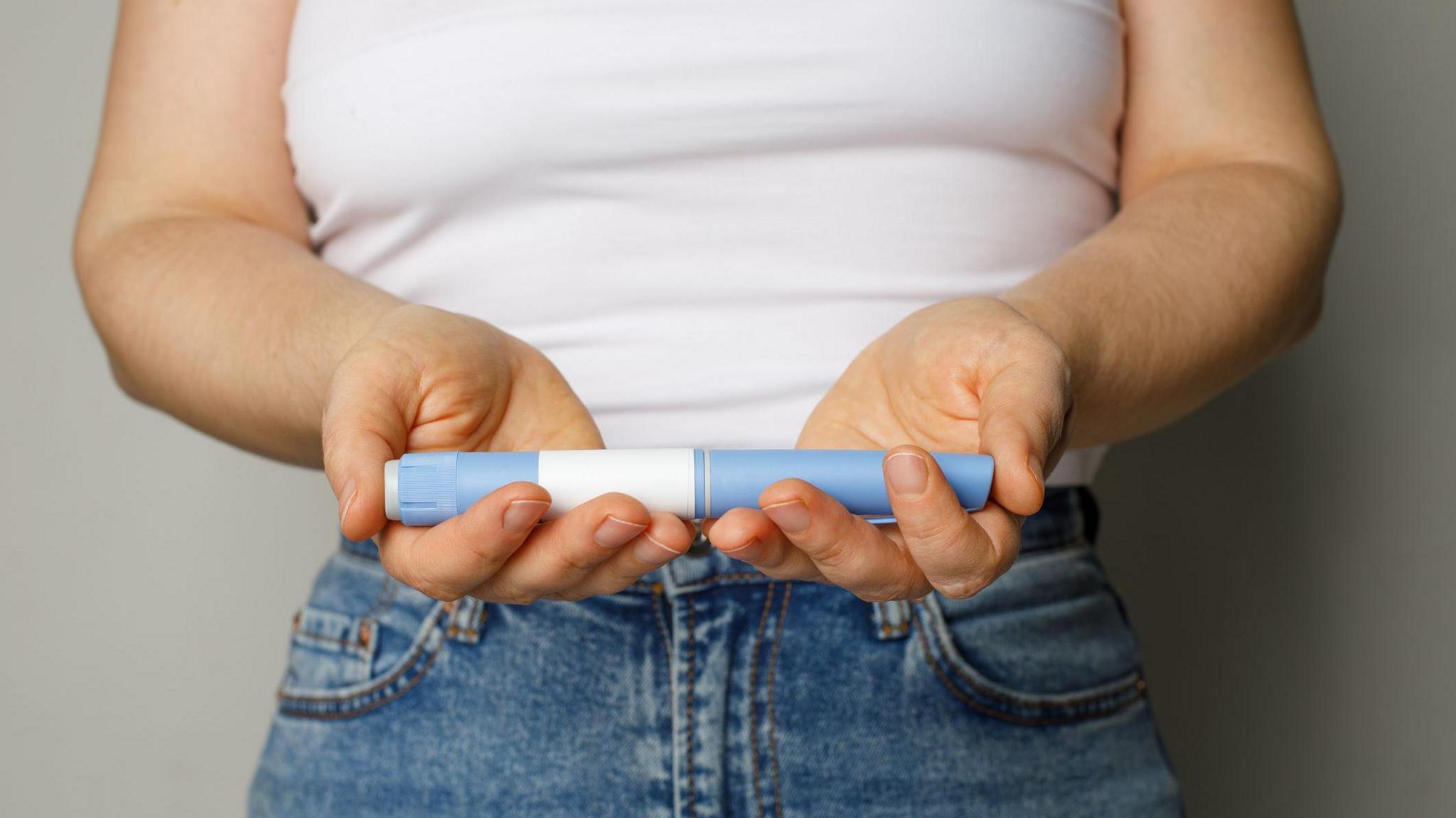 Woman holding a weight-loss jab