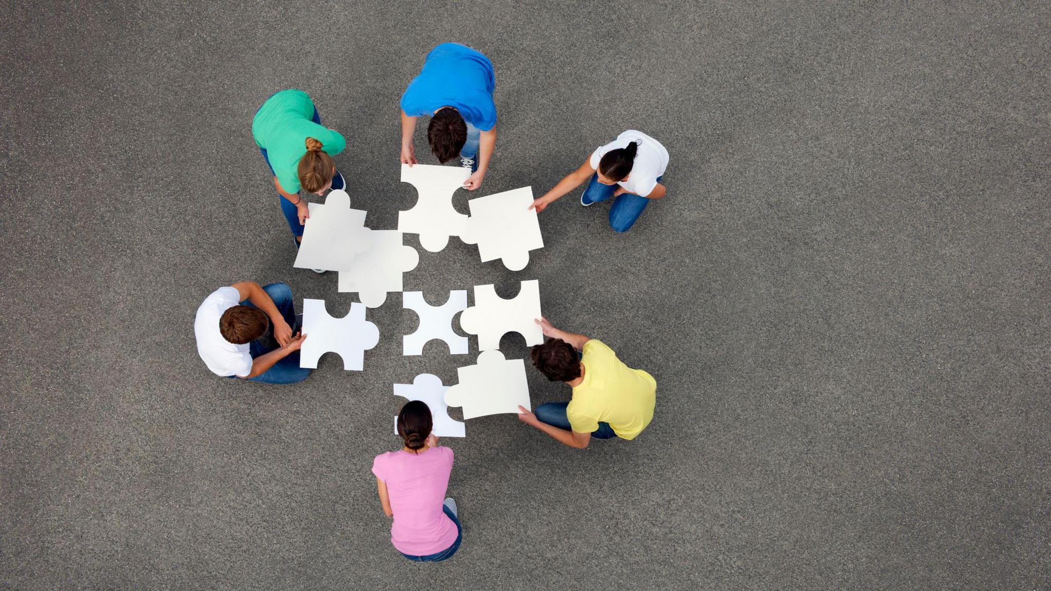 People putting together jigsaw puzzle - stock photo