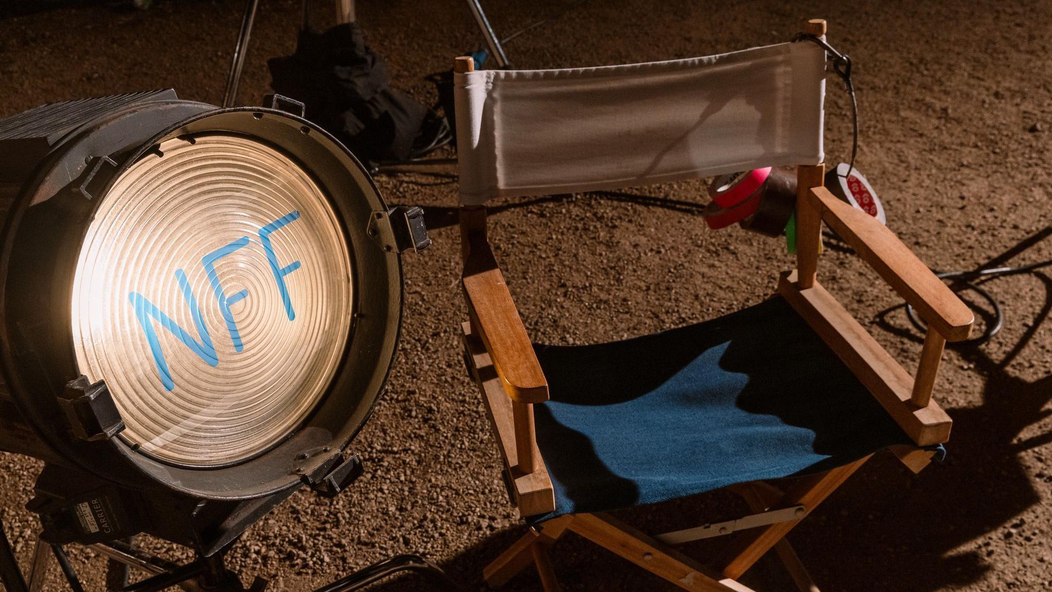 A blue directors chair positioned next to a large night with the letters "NFF" etched in blue. 