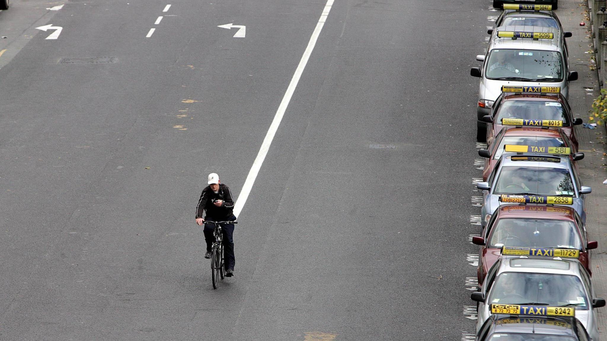 A cyclist makes his way past a taxi rank on St Stephen's Green in Dublin