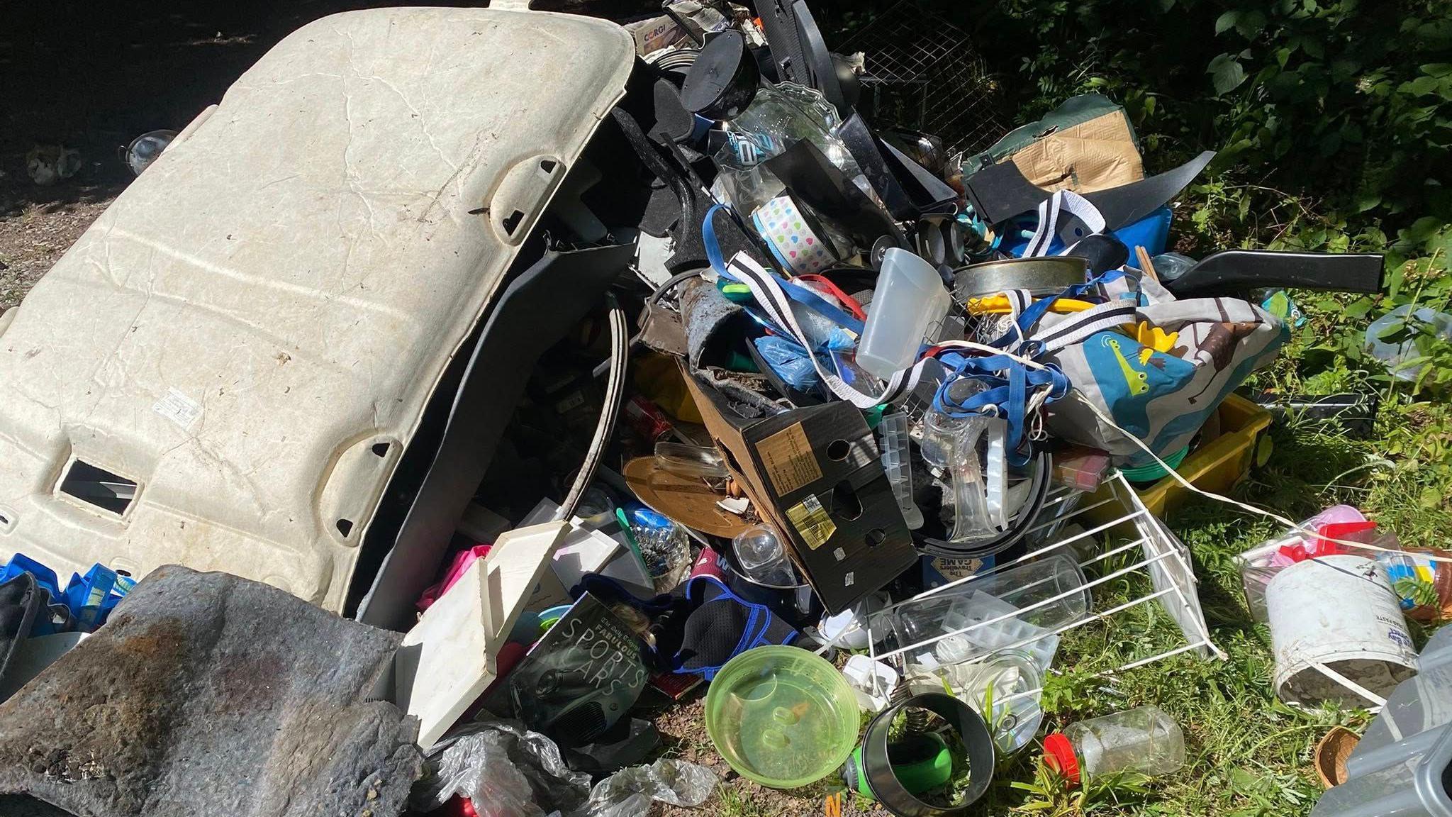 Fly-tipped rubbish including household items.