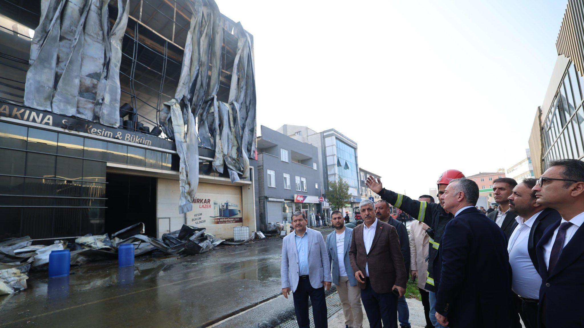 Mayor of Kocaeli Metropolitan Municipality Tahir Buyukakın is shown the fire ravaged building by a firefighter 