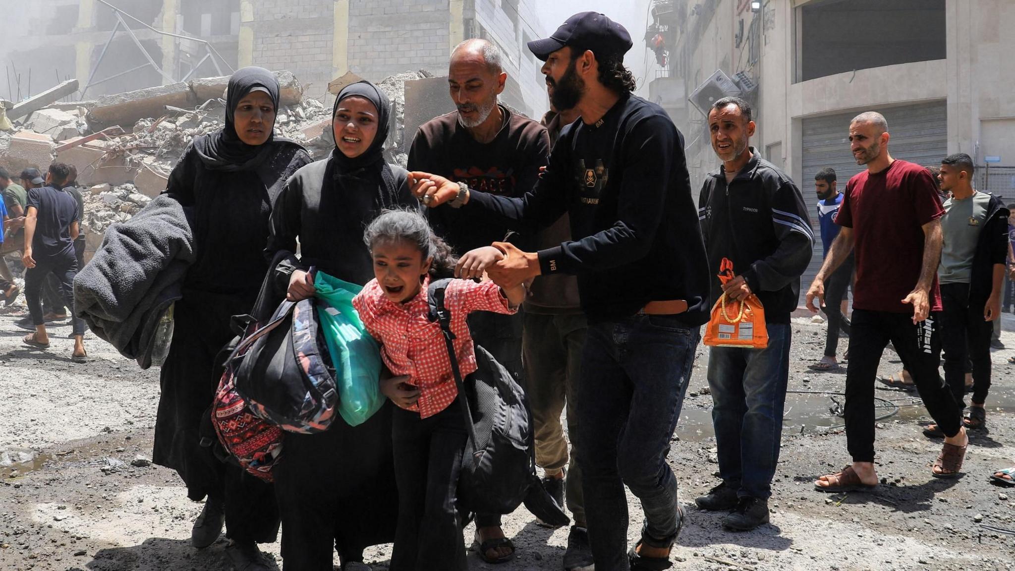 Palestinians flee an area of Gaza City following an Israeli air strike on a house (30 May 2025)