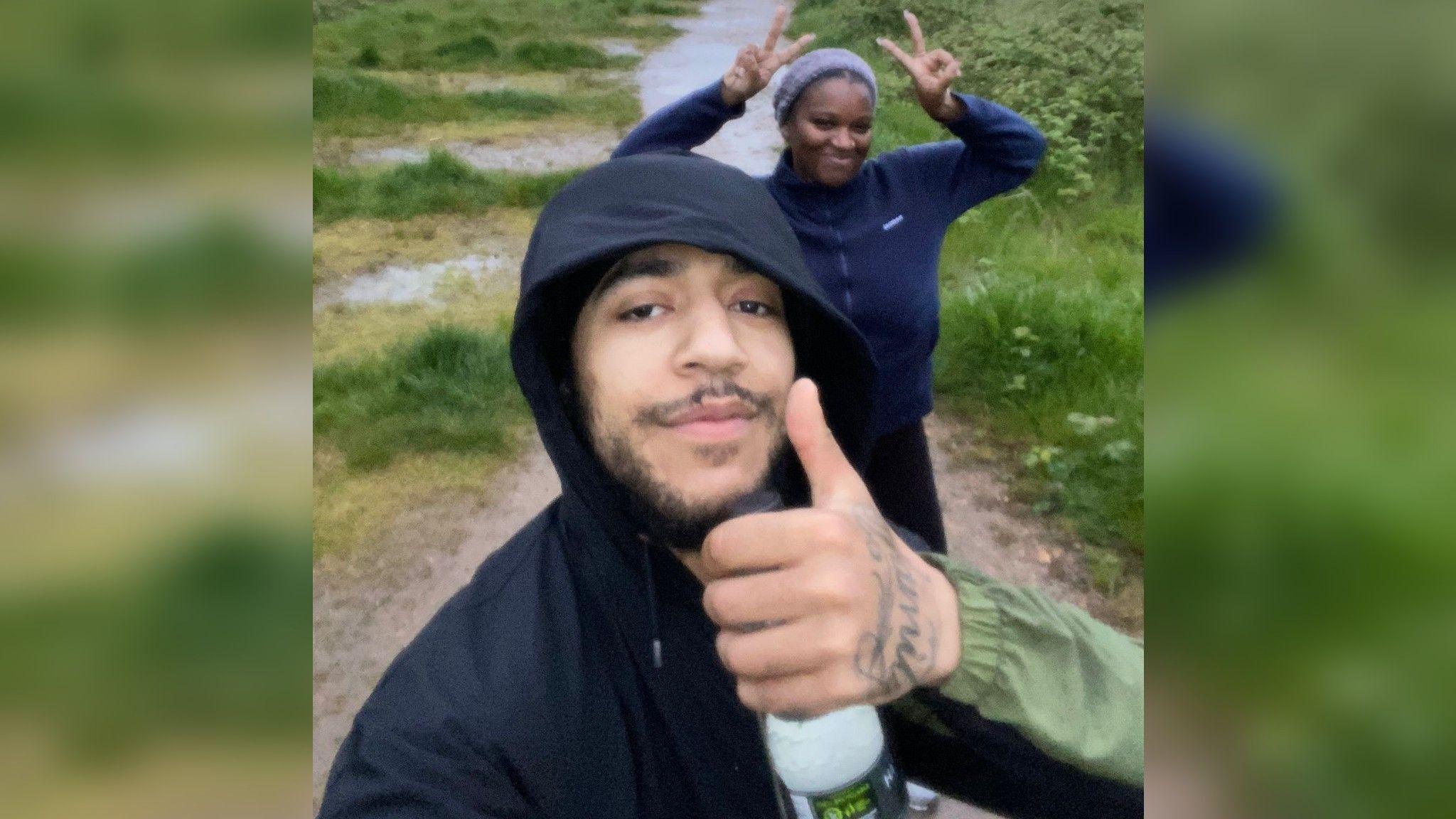 Myles and a friend on a walk, Myles has is thumb up looking at the camera