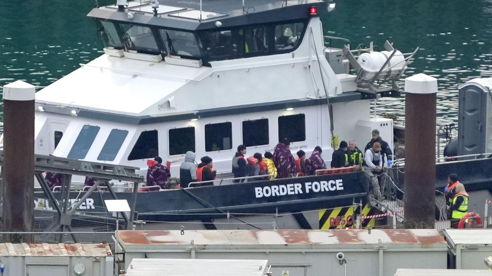 Migrants disembark a Border Force boat in Dover