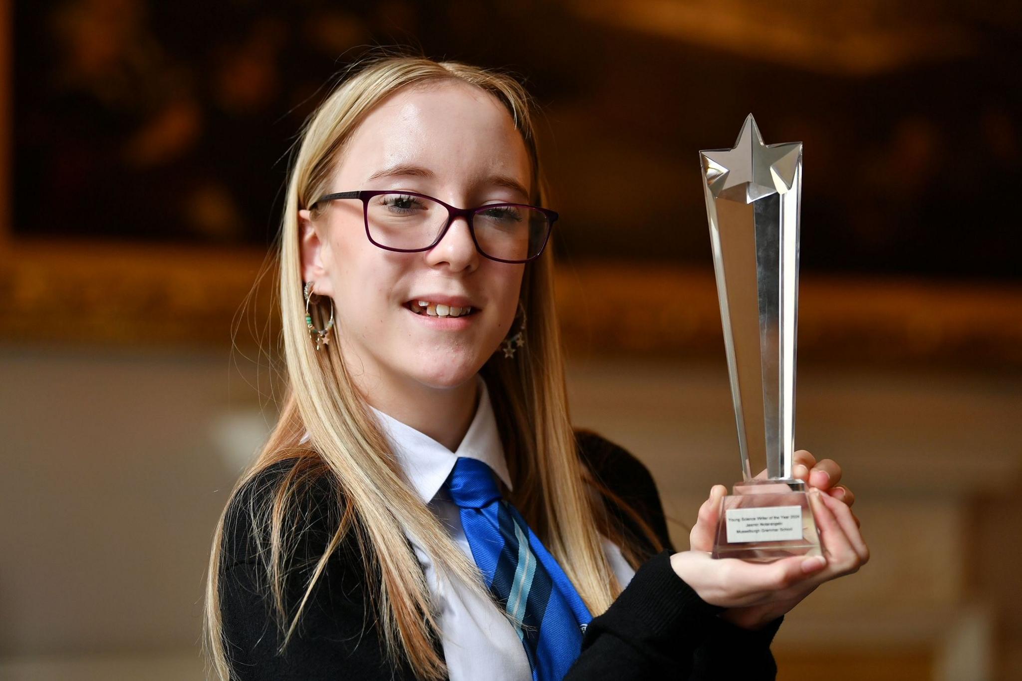 Jasmin Notarangelo, winner of the 2024 Young Science Writer of the Year award, holds up her award