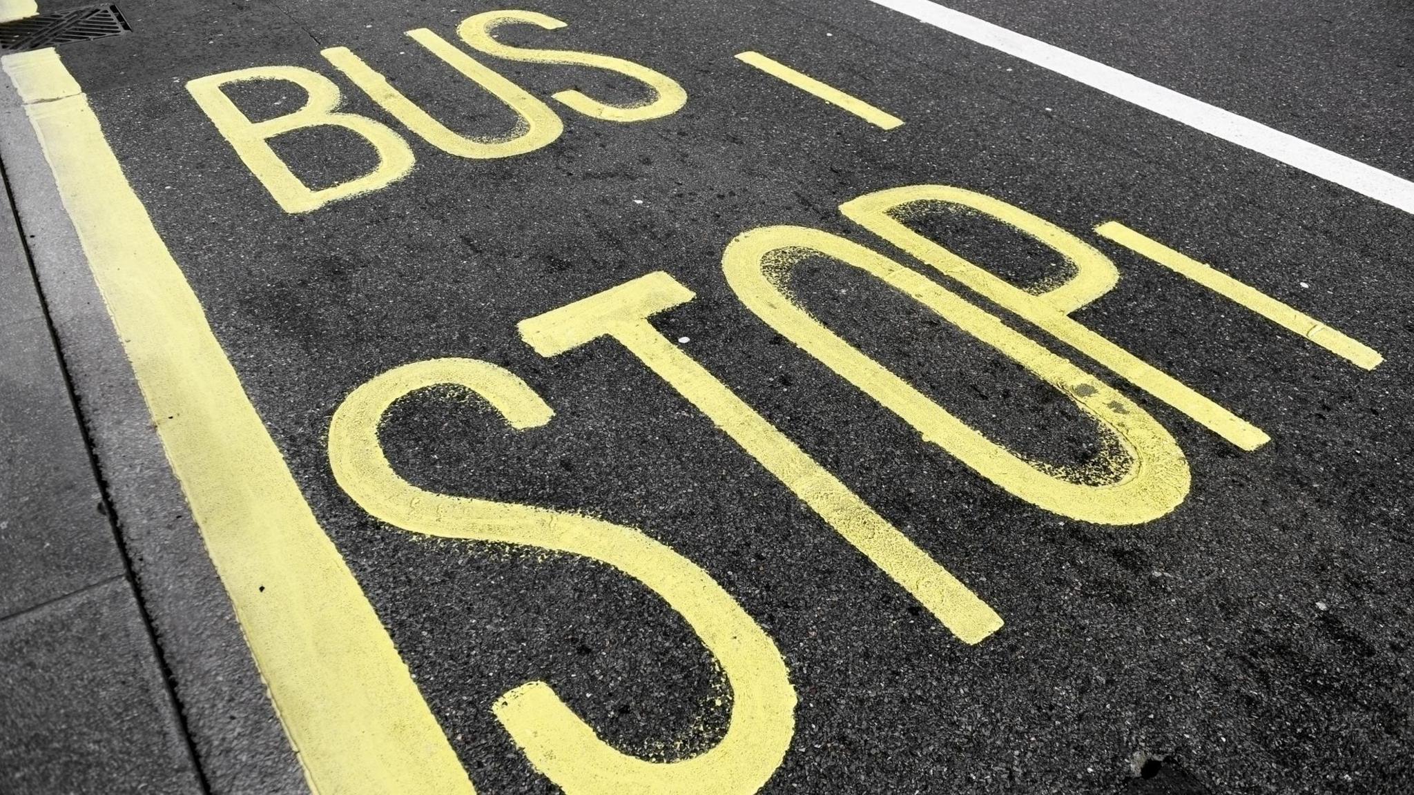 A yellow road marking which says 'bus stop' in capital letters